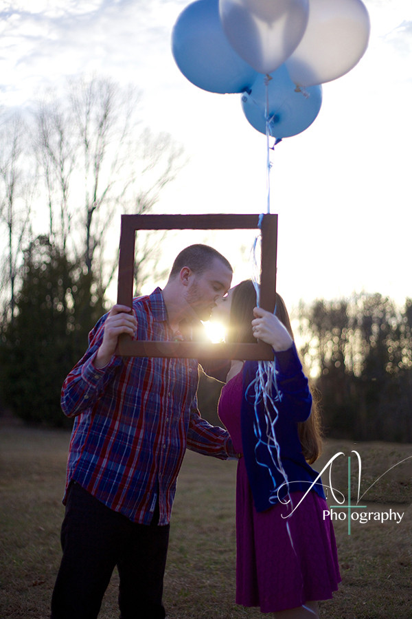 A picture perfect moment of a couple sharing an intimate kiss in a field with balloons during their Downtown Concord Engagement Session