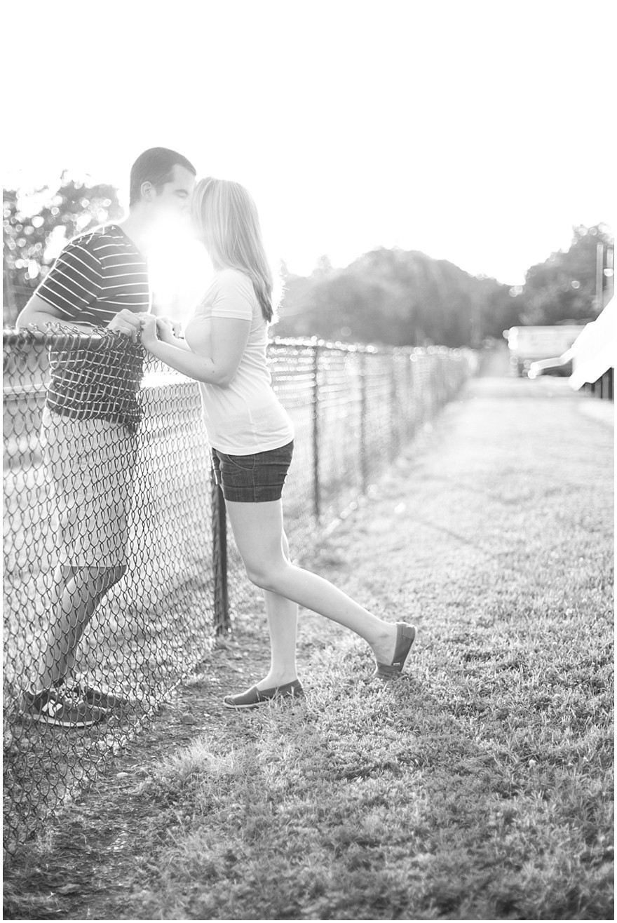 Downtown Matthews Charlotte engagement photos kissing on fence