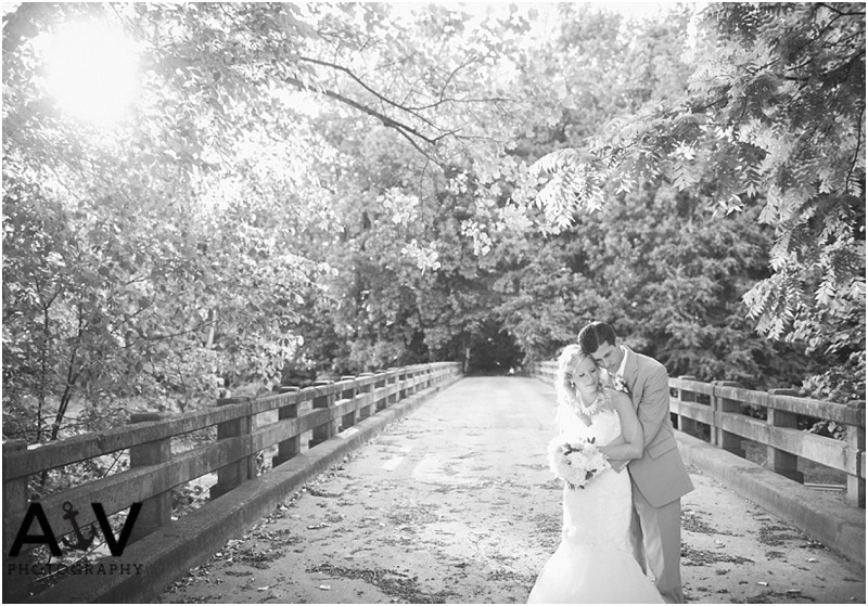 Bride and groom in an romantic, emotional pose on the bridge at the Winmock at Kinderton in Winston Salem