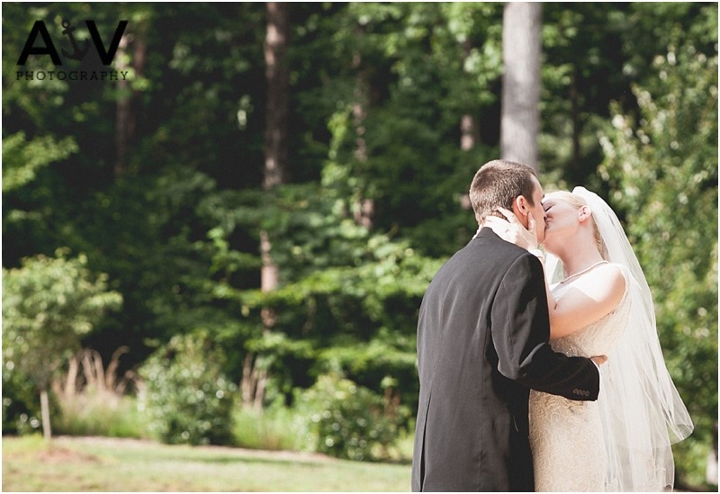 Bride and groom kissing during their outside wedding ceremony at the summerfield amphitheater
