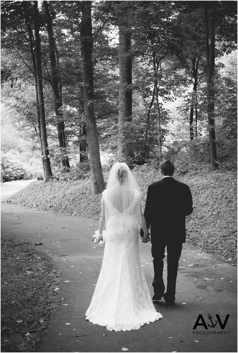 Bride and groom after the wedding ceremony walking down the trail at the summerfield amphitheater in north carolina