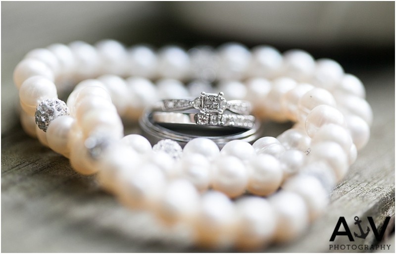 The brides pearl necklace and wedding rings at the summerfield amphitheater in north carolina