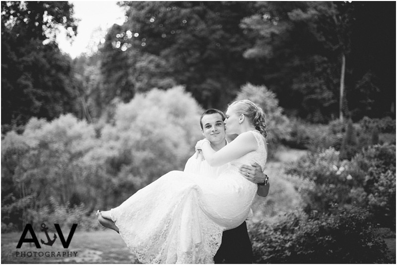 Groom holding the bride in his arms and her kissing him on the cheek in summerfield North Carolina