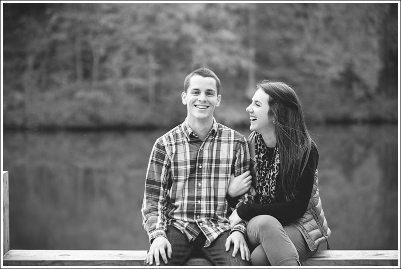 a genuine look of love on the dock during at the lake during the fall engagement session at reedy creek park in Charlotte North Carolina