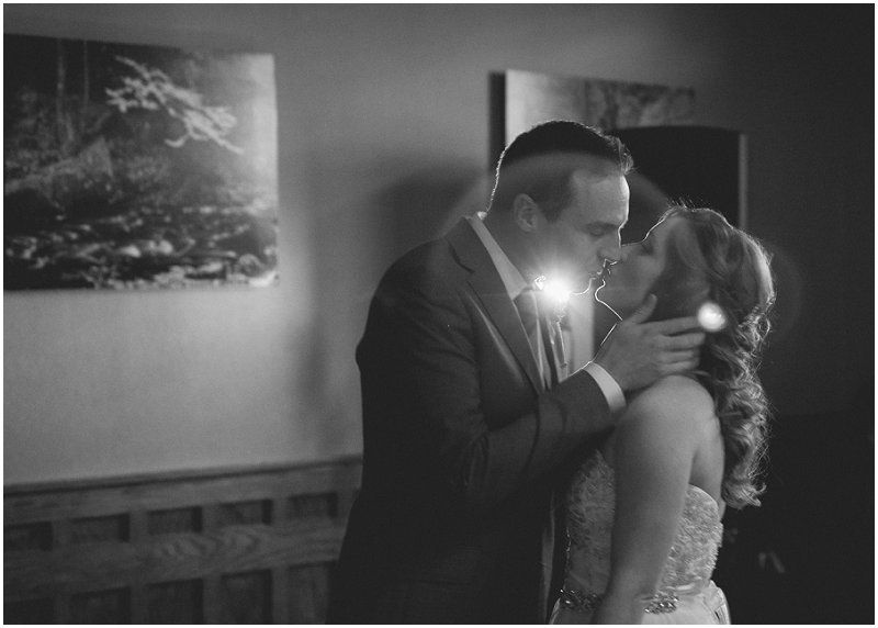 Bride and groom sharing a kiss during the reception at the Waterfront wedding at the chetola resort and spa in Blowing rock North Carolina
