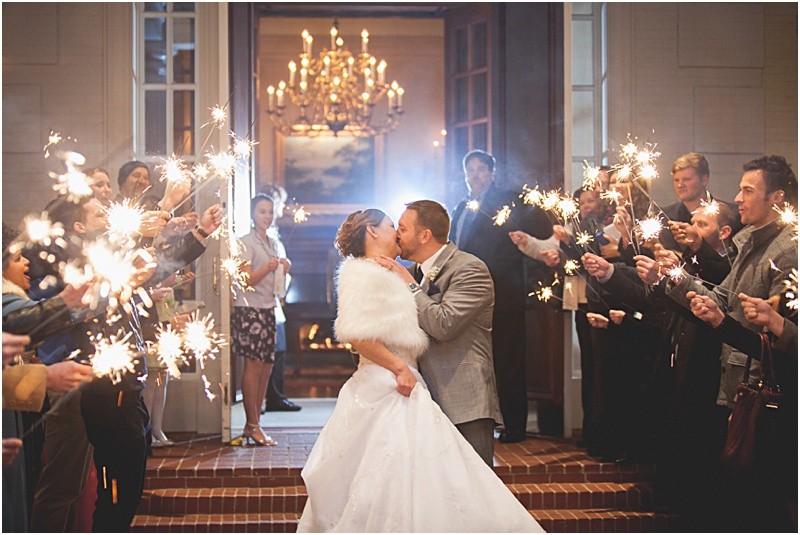 The perfect sparkler exit as the bride and groom leave the reception in her fur wrap over the wedding dress on a cold night during the High Point North Carolina Wedding at First Baptist Church High Point and high point country club at Emerywood