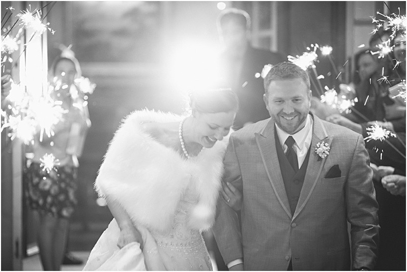 Bride and groom leaving the reception during the sparkler exit with a fur wrap during the High Point North Carolina Wedding at First Baptist Church High Point and high point country club at Emerywood