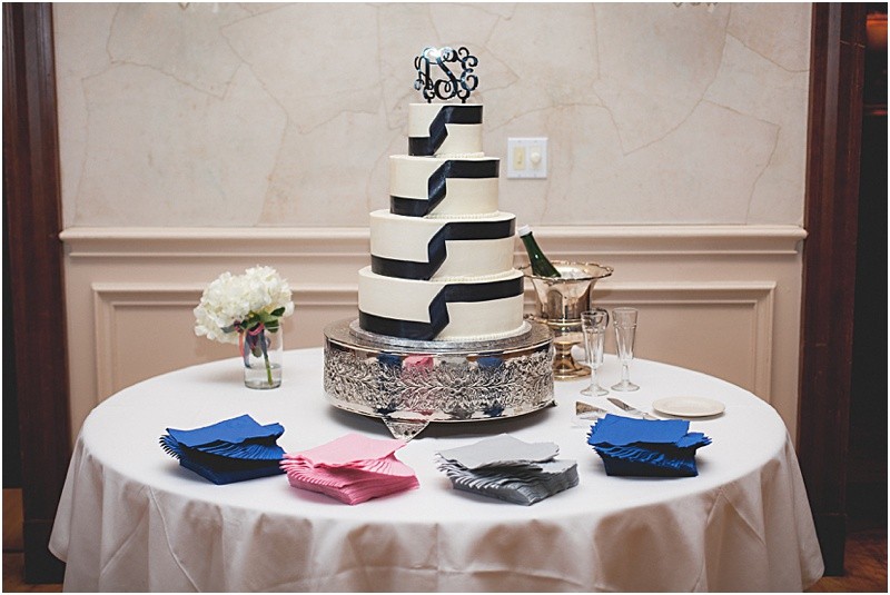 A large white cake with dark ribbon at the reception during the sparkler exit with a fur wrap during the High Point North Carolina Wedding at First Baptist Church High Point and high point country club at Emerywood