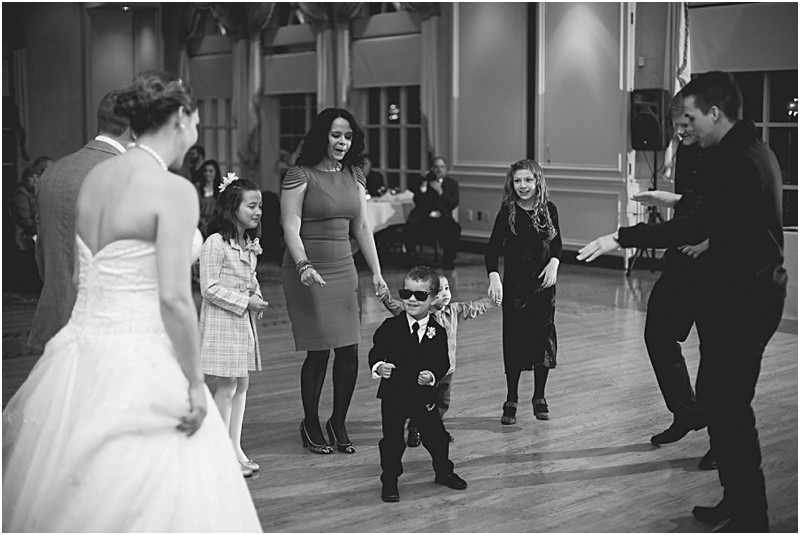 The ring bearer wearing sunglasses during the reception during the sparkler exit with a fur wrap during the High Point North Carolina Wedding at First Baptist Church High Point and high point country club at Emerywood