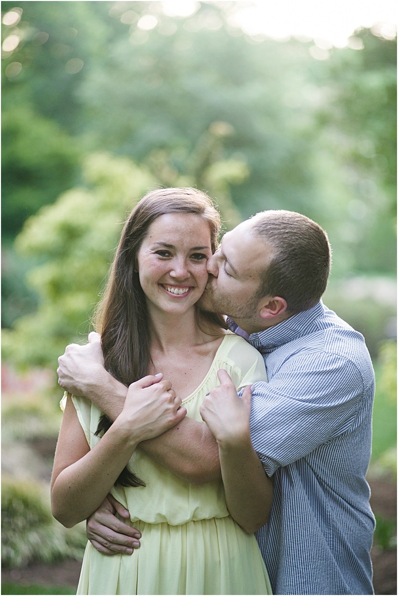 sneaking up behind her during the engagement session at burr mill park and the greensboro bicentennial gardens