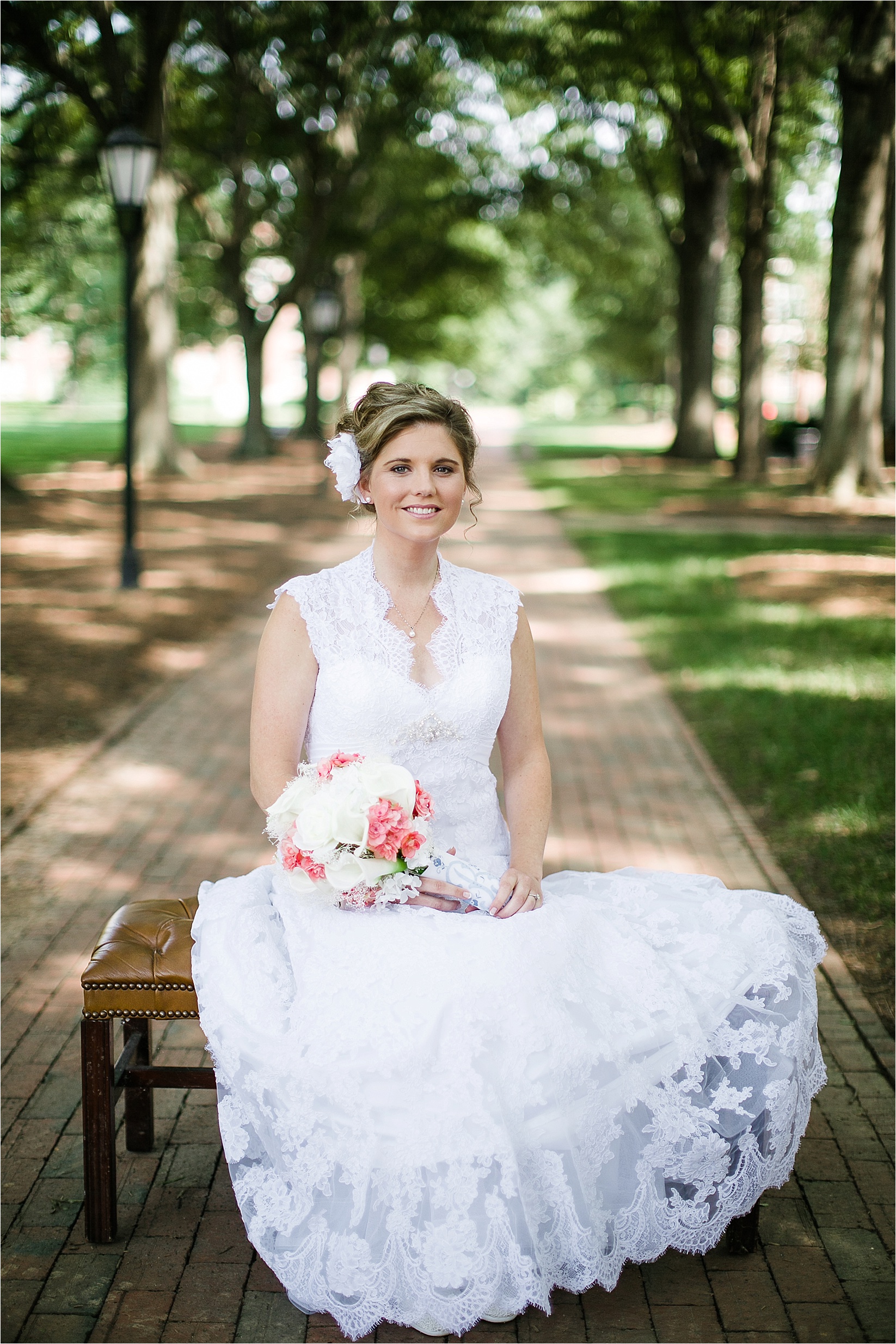 Bride sitting on a bench on the path at the davidson college chapel wedding in Davidson north Carolina and the Charles mack citizen center wedding and reception