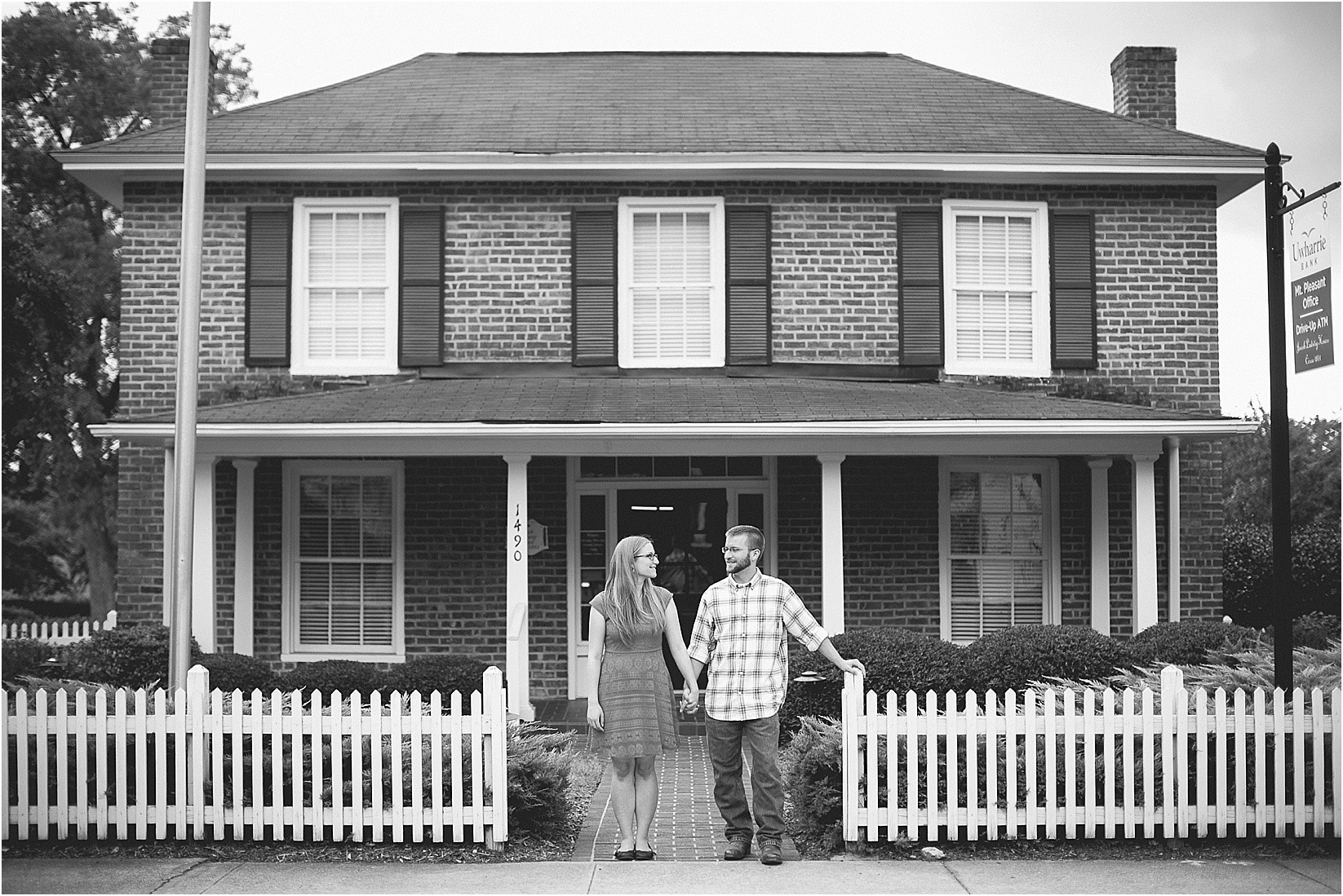 standing in front of the old house during Andria & Matts Mount Pleasant engagement session in downtown mount pleasant nc