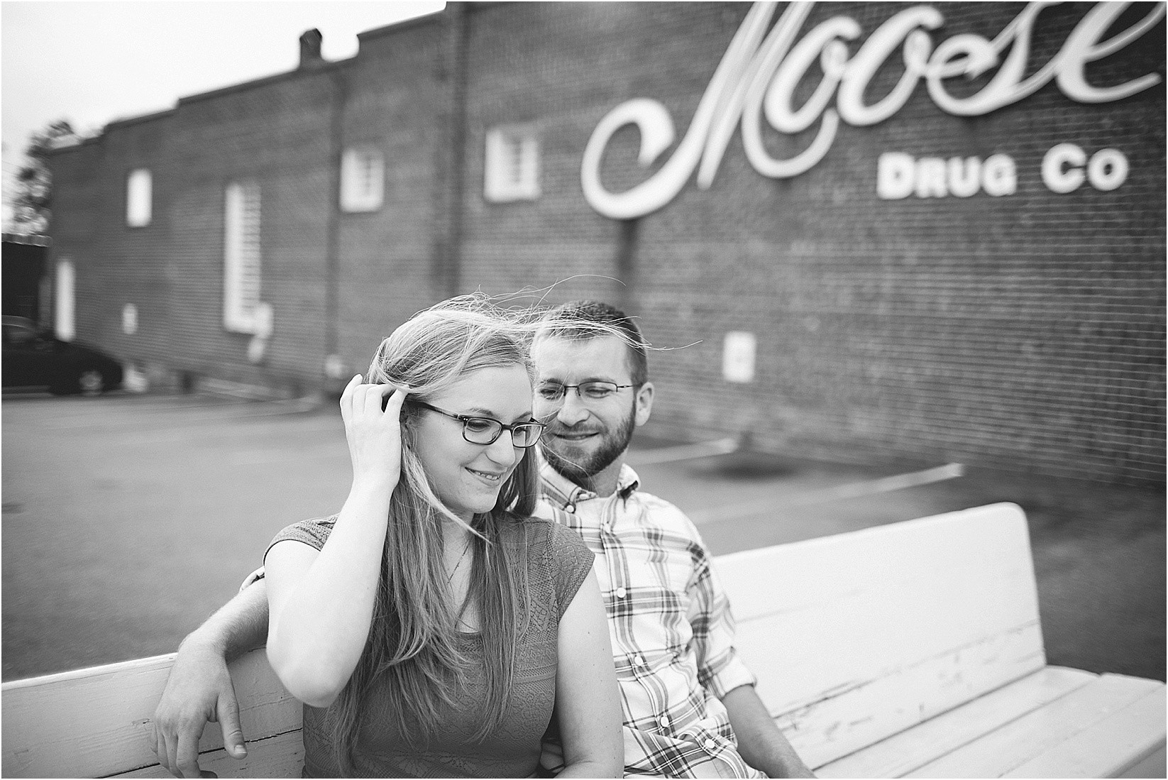 Hair blowing in the wind while sitting in front of moose during Andria & Matts Mount Pleasant engagement session in downtown mount pleasant nc