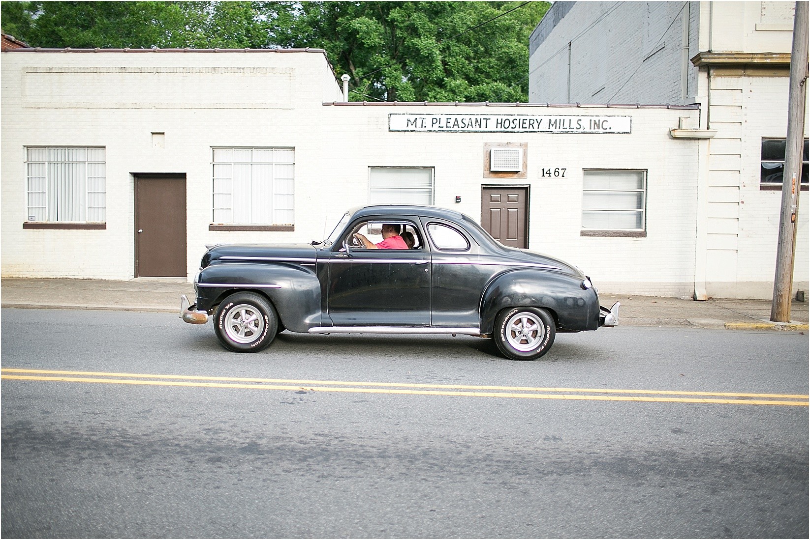 vintage car driving during Andria & Matts Mount Pleasant engagement session in downtown mount pleasant nc