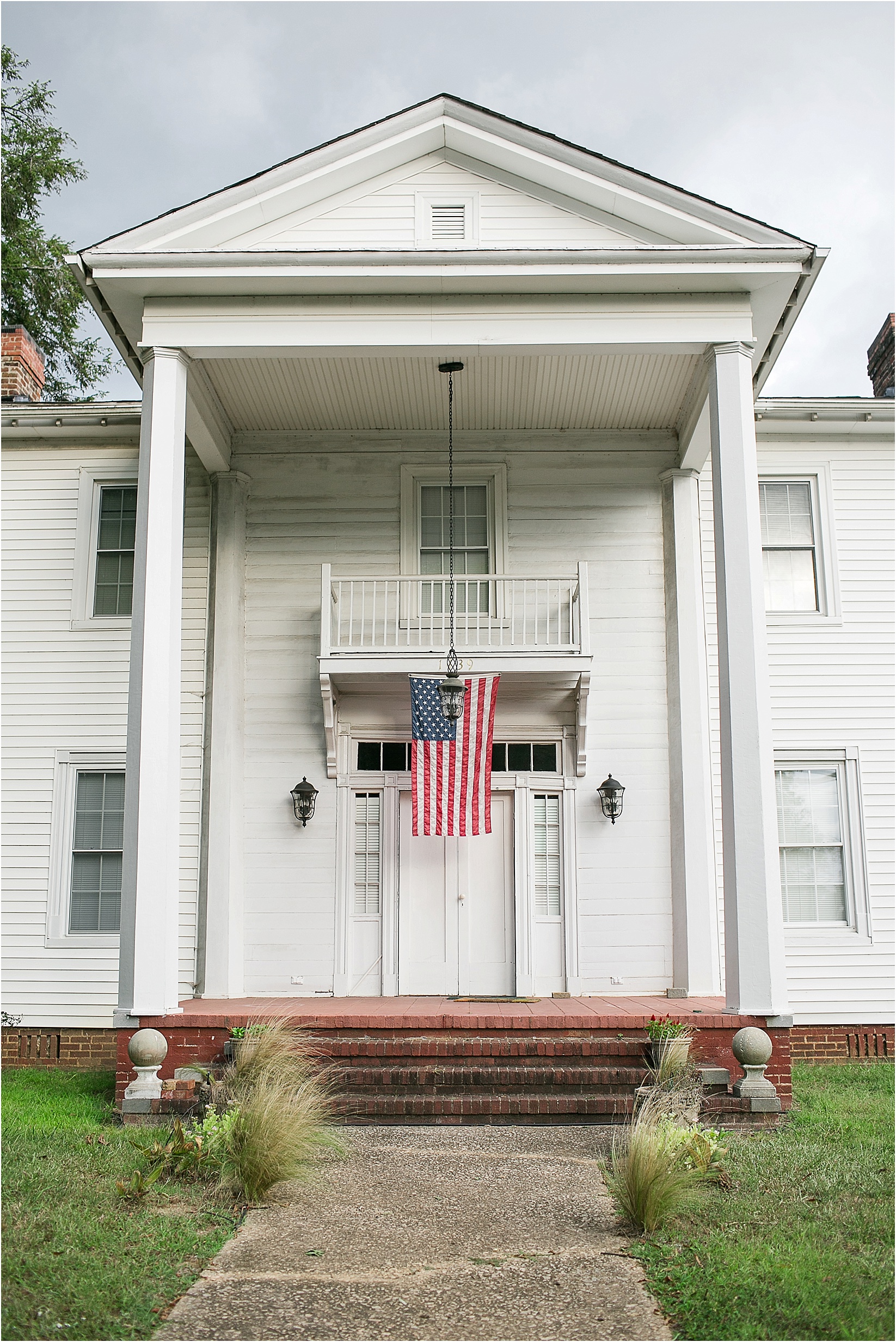 american flag on the mayors house during Andria & Matts Mount Pleasant engagement session in downtown mount pleasant nc