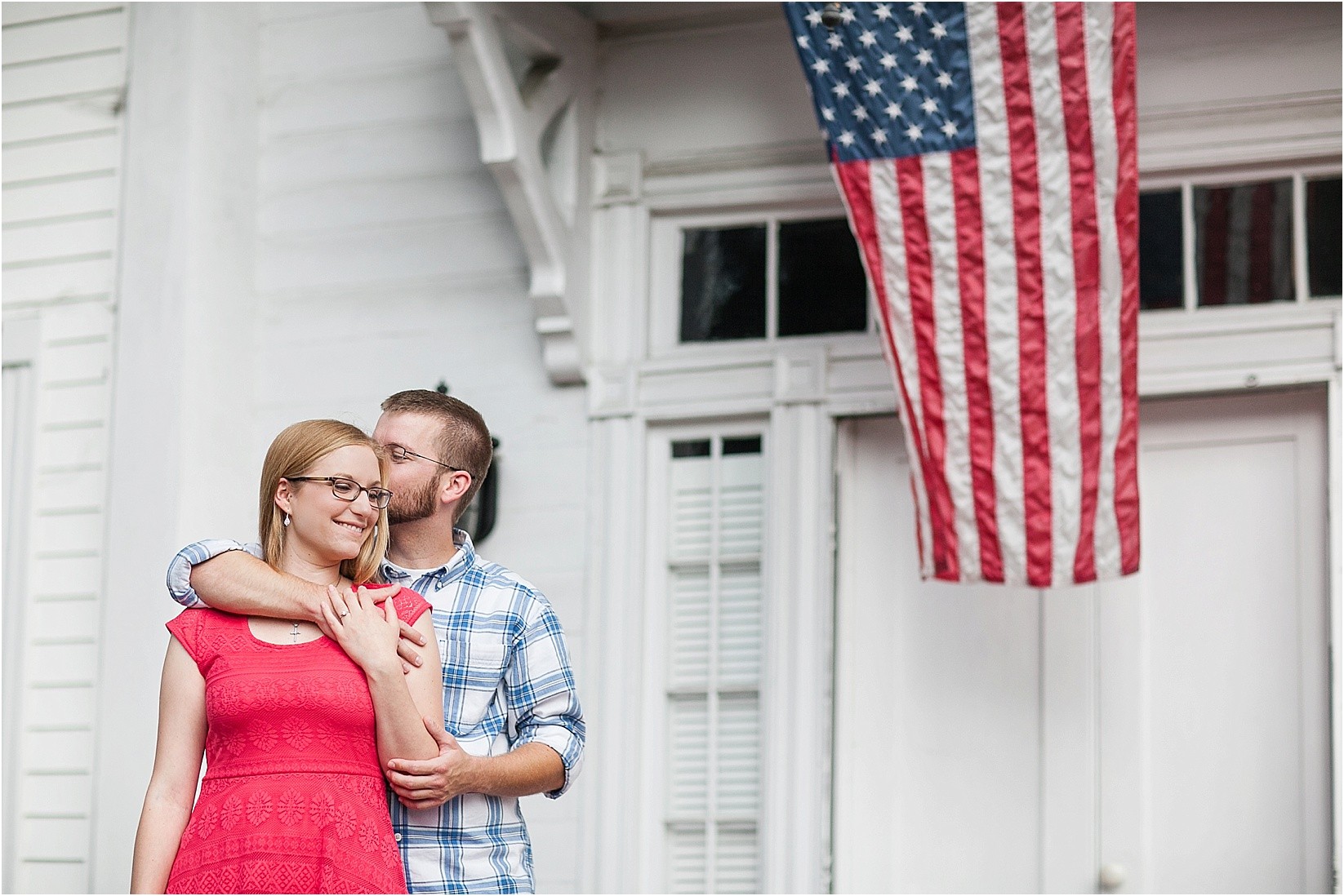 american flag on the porch and kissing during Andria & Matts Mount Pleasant engagement session in downtown mount pleasant nc