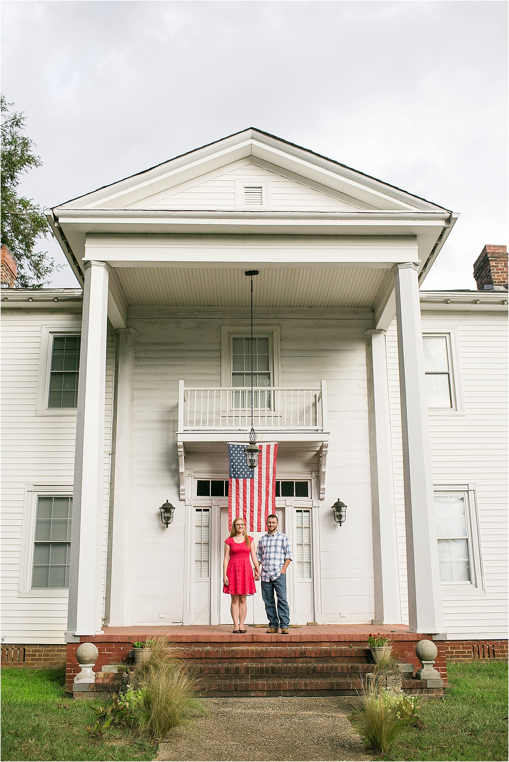 standing not he mayors porch during Andria & Matts Mount Pleasant engagement session in downtown mount pleasant nc