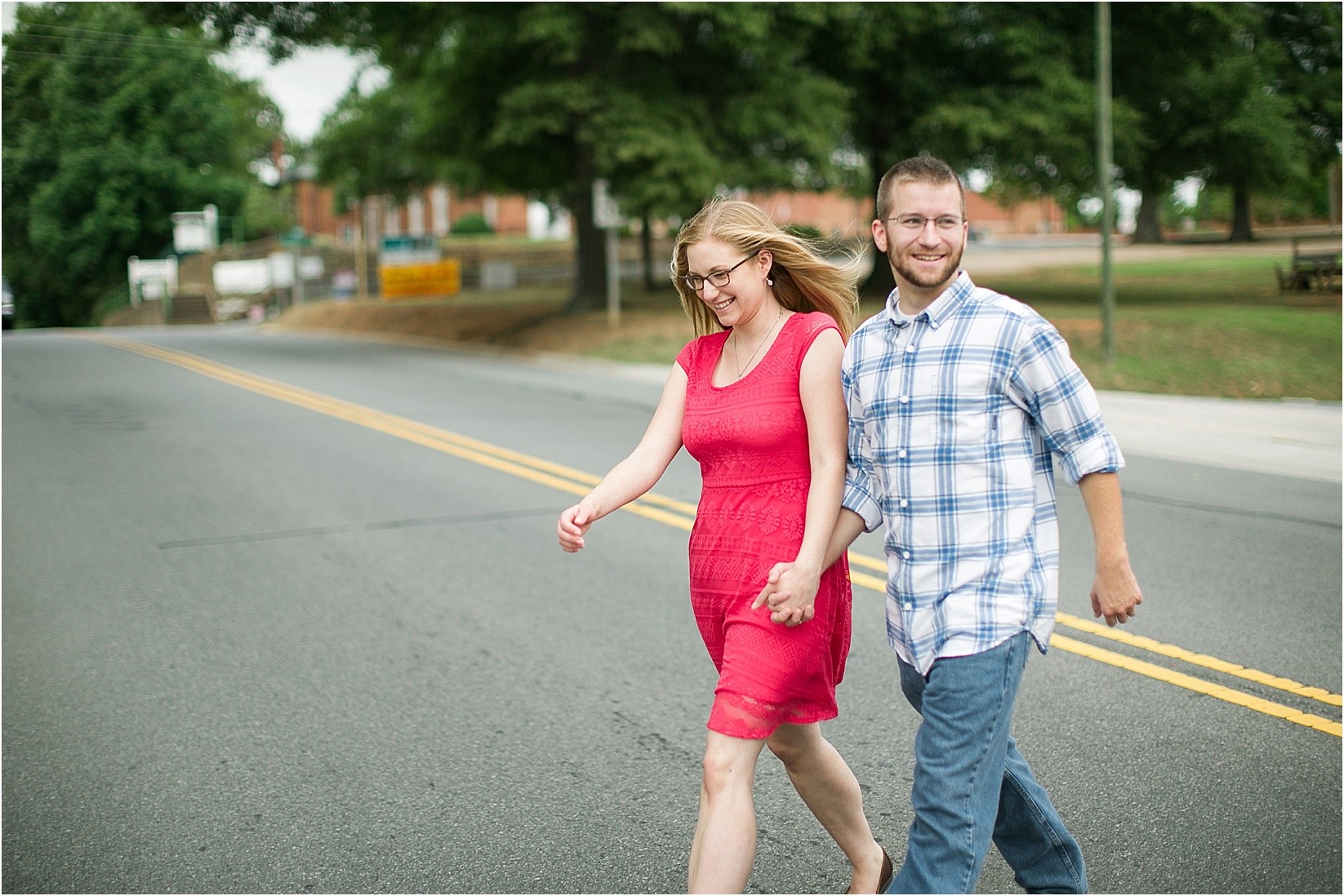 walking across the street during Andria & Matts Mount Pleasant engagement session in downtown mount pleasant nc