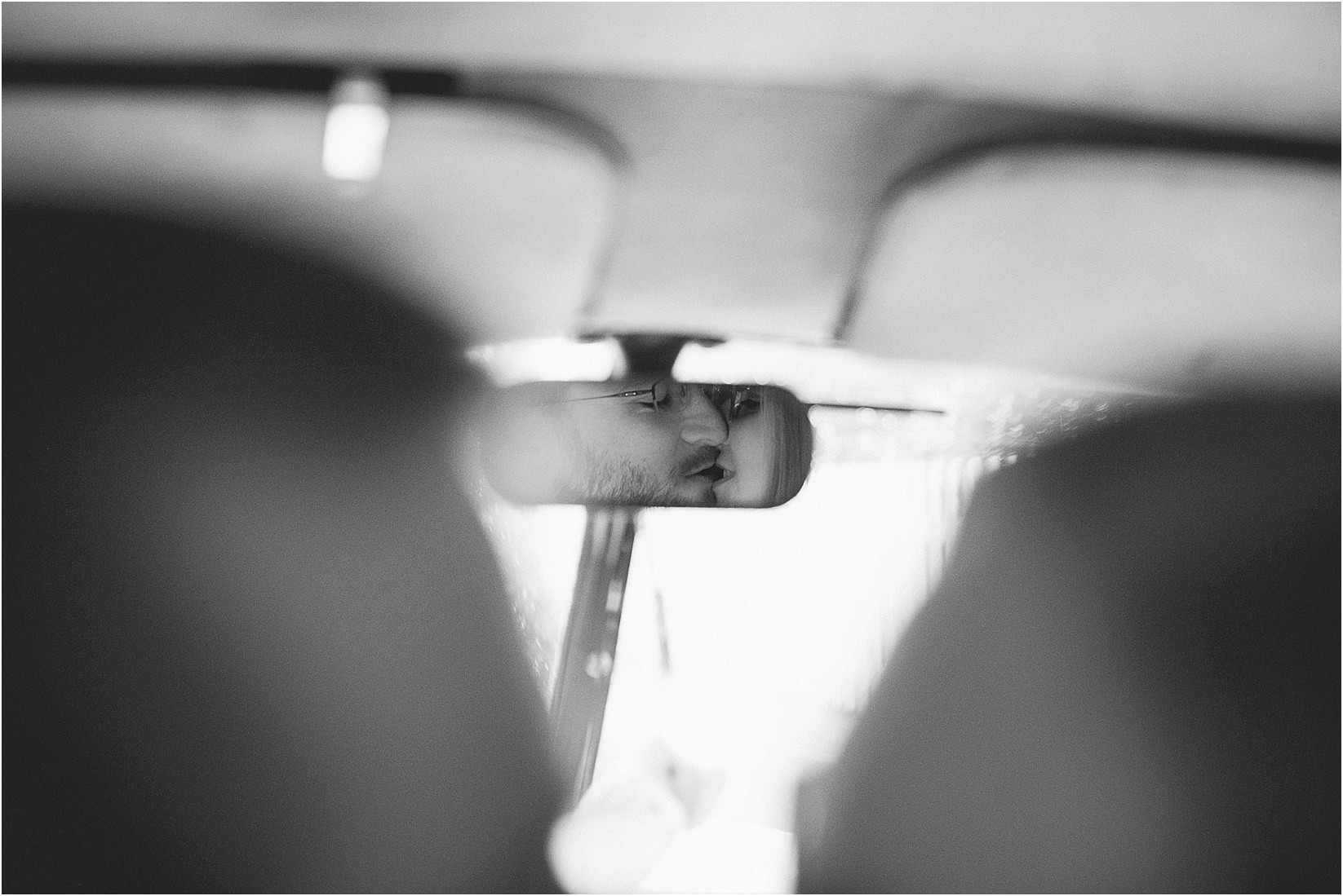 kissing in the rearview mirror during Andria & Matts Mount Pleasant engagement session in downtown mount pleasant nc