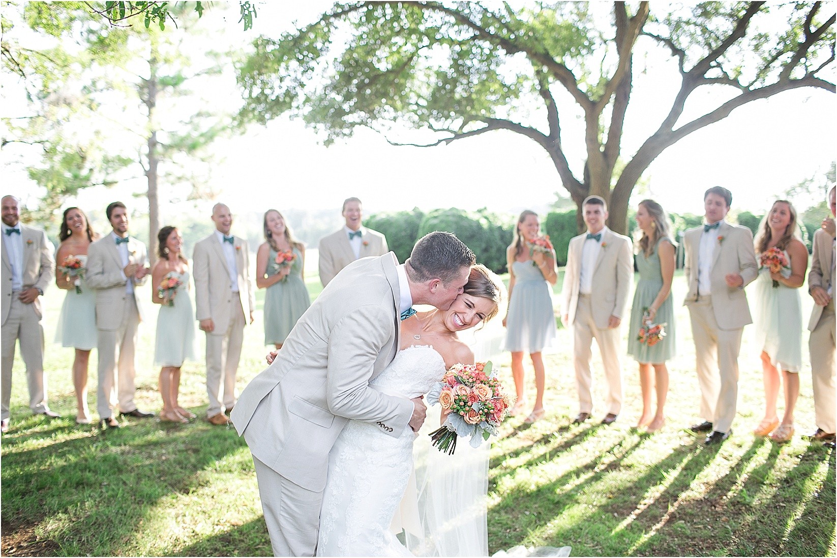 kissing in front of the bridal party during their wedding at the Historic Rural Hill wedding ceremony and reception in Huntersville nc
