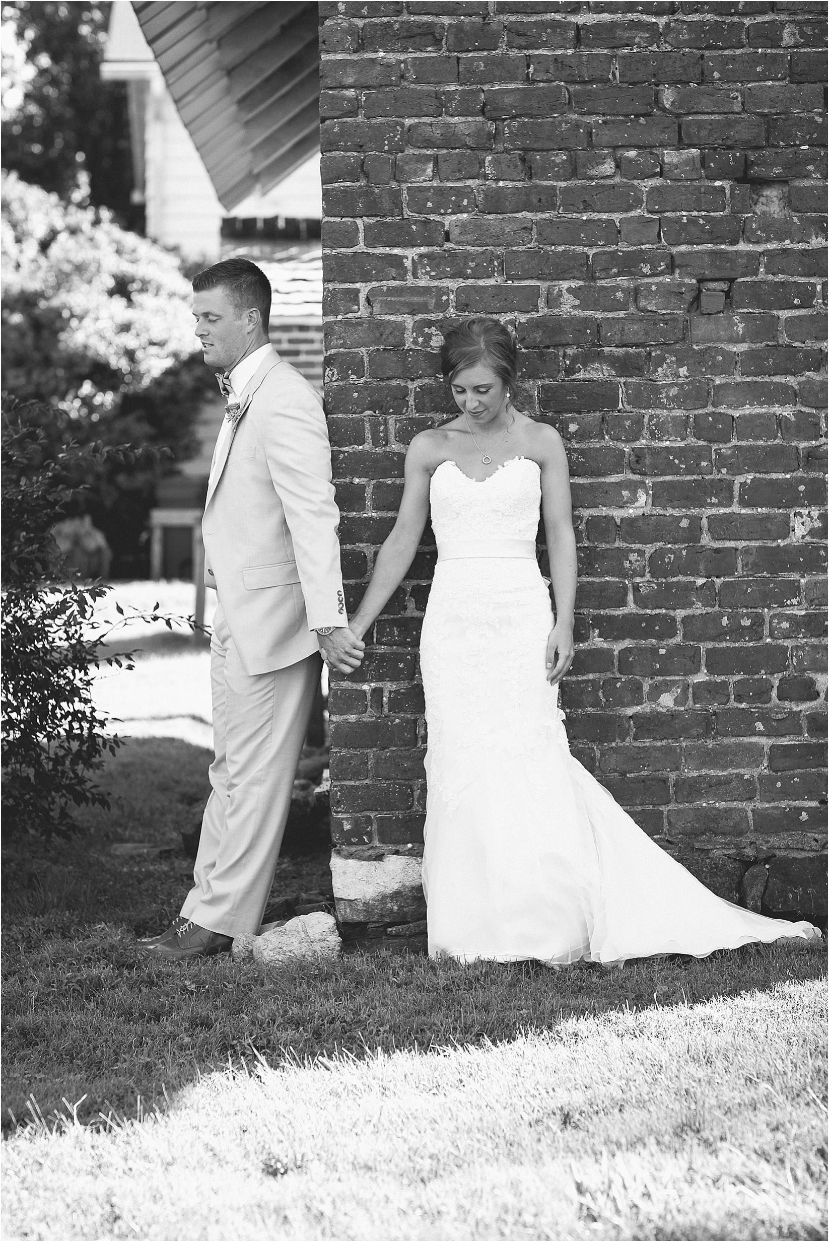 praying holding hands around the corner during their wedding at the Historic Rural Hill wedding ceremony and reception in Huntersville nc