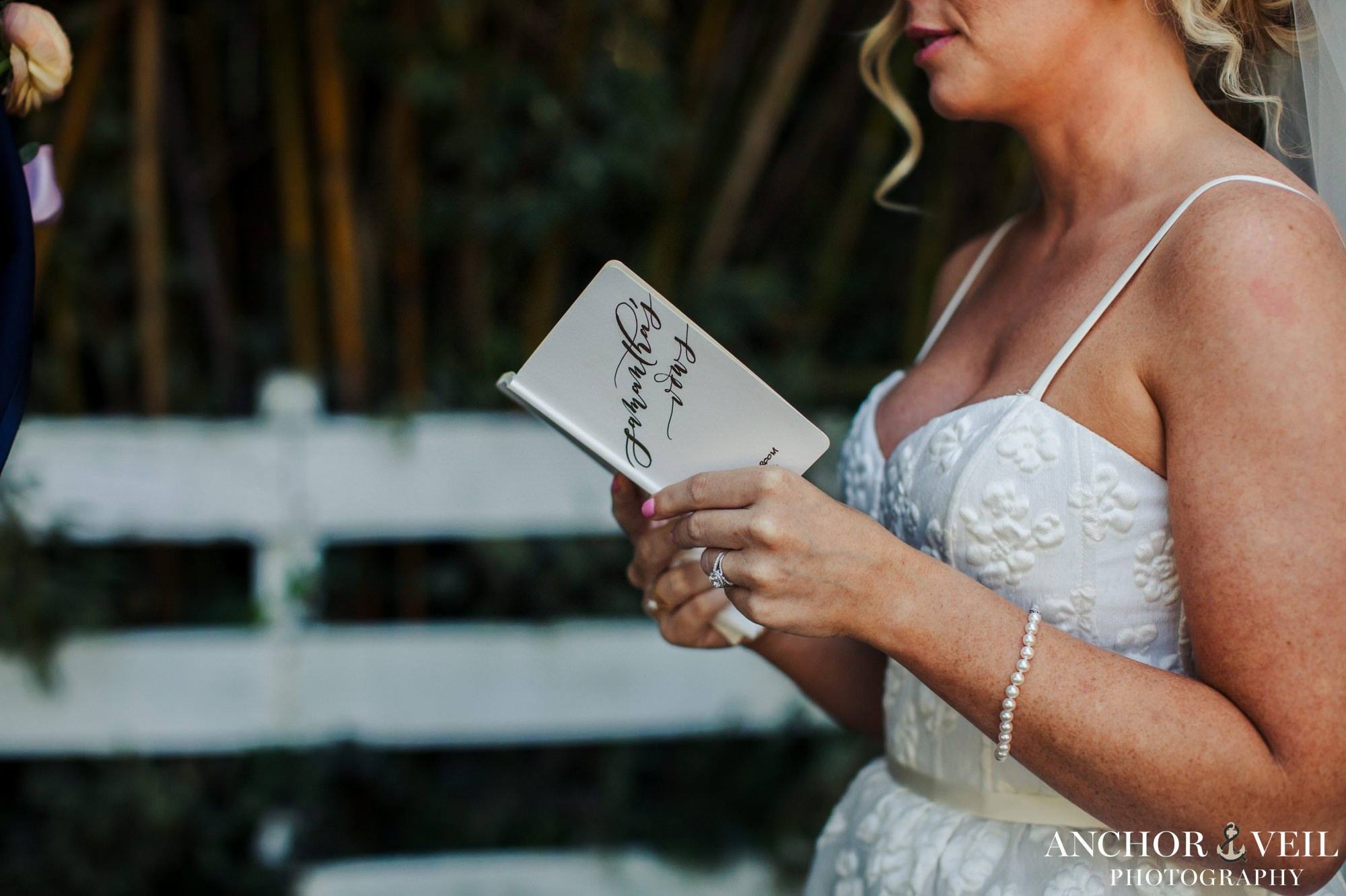 bride reading her vows out of the vow boo