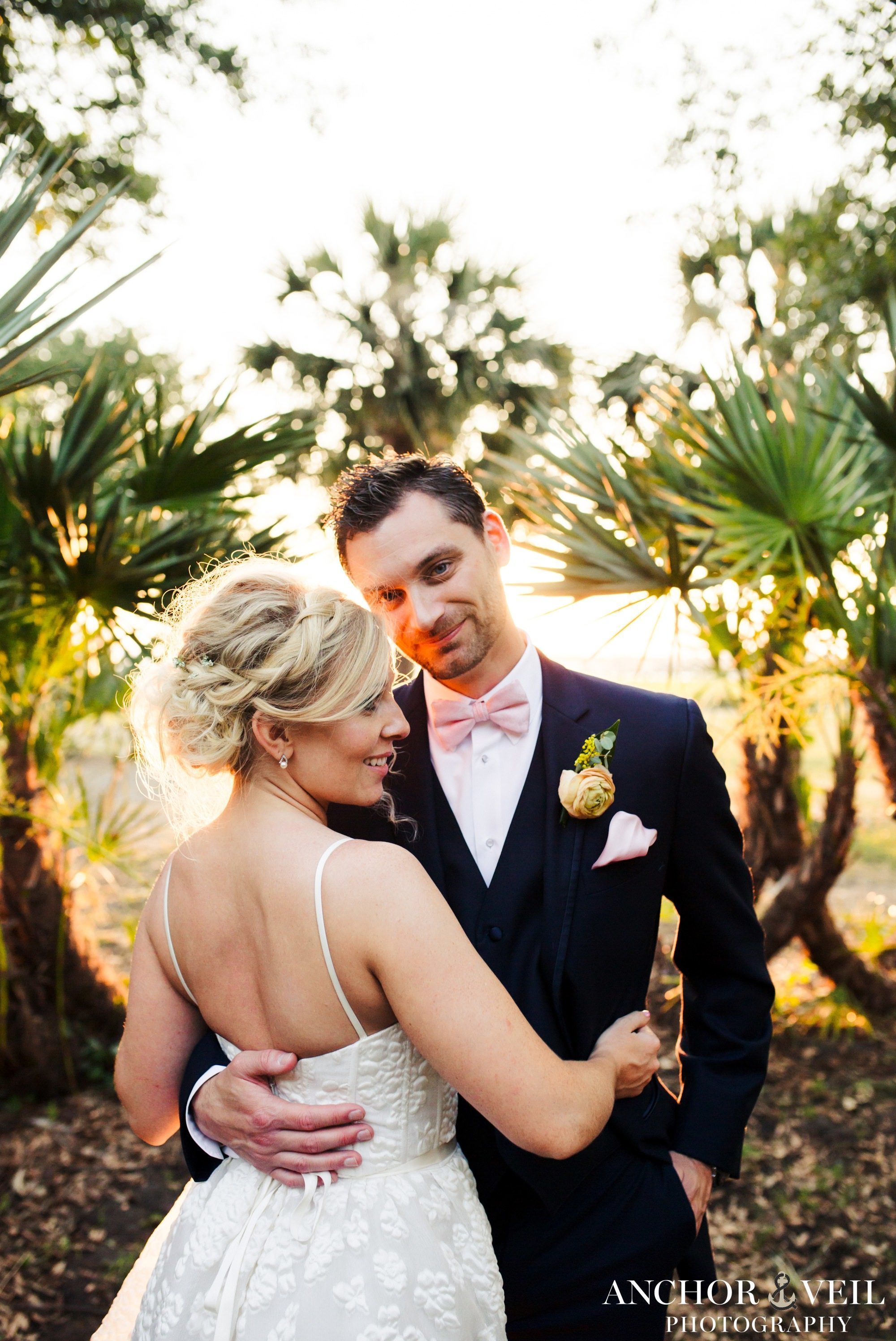 groom pictures in the light between the palm trees