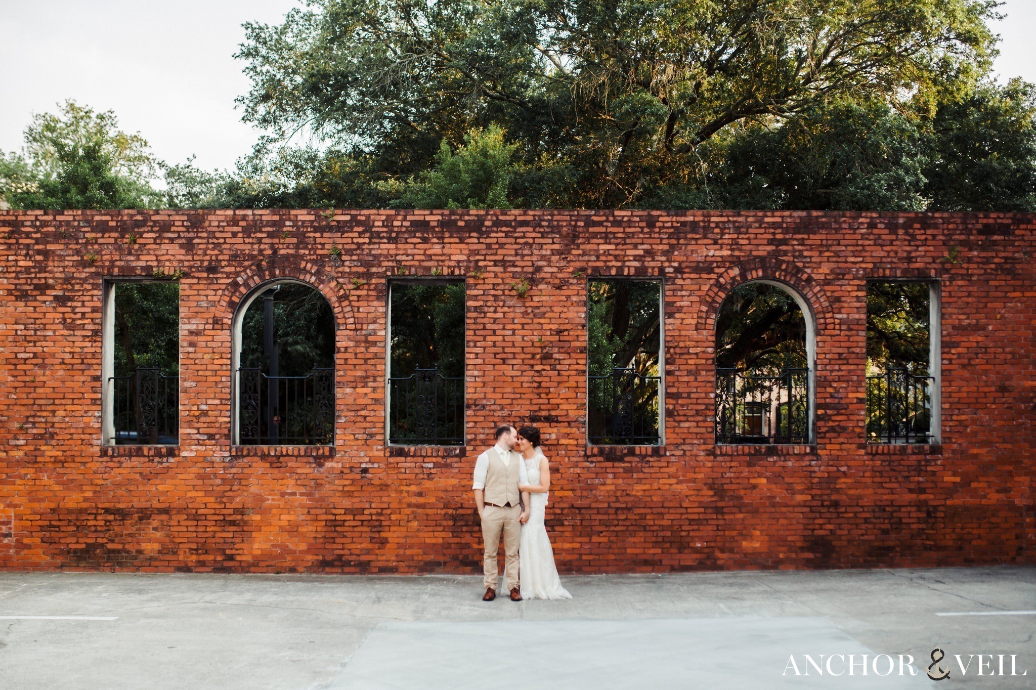 standing in front of a brick wall during their Forsyth Park Wedding Elopement
