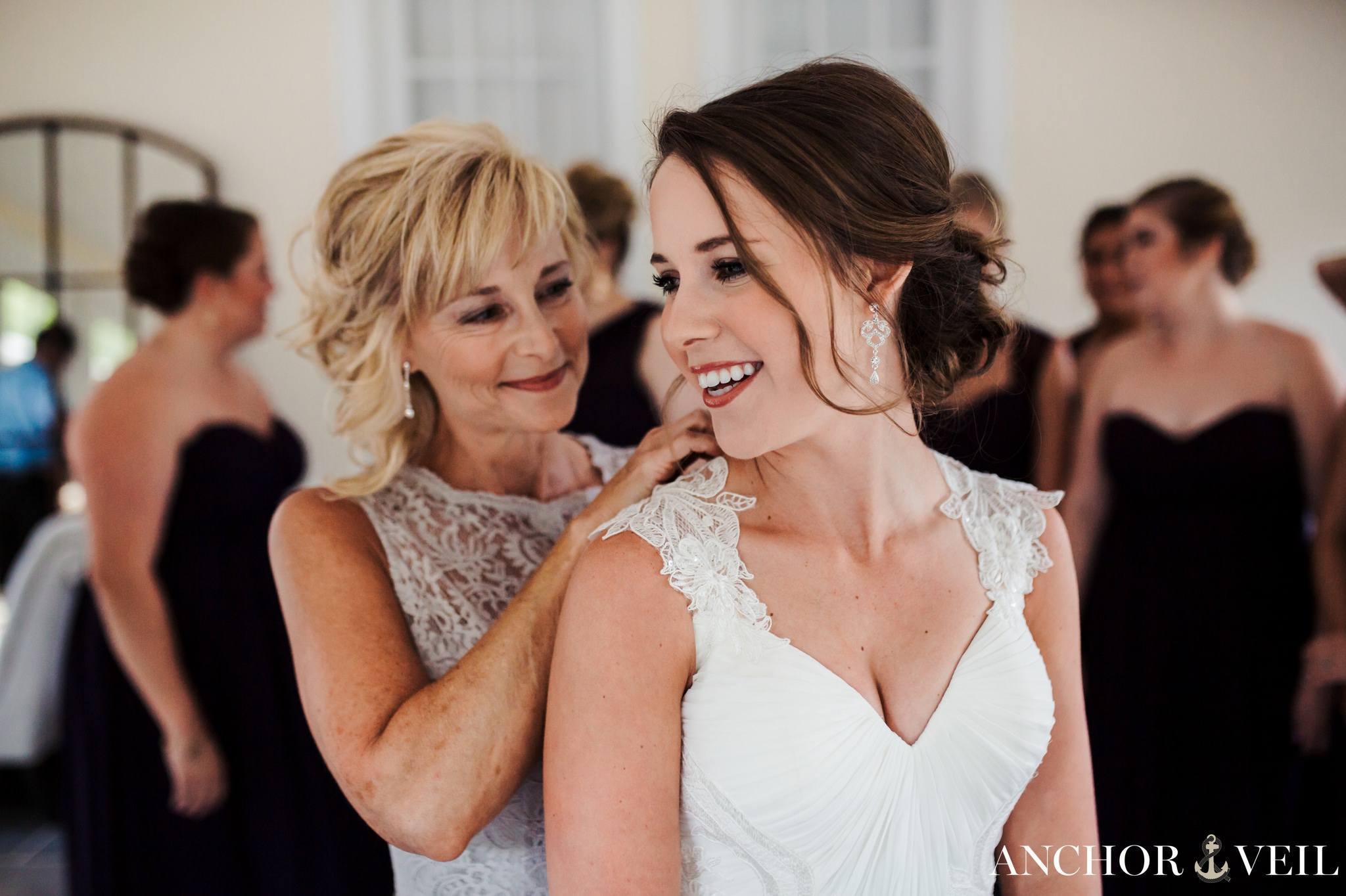 brides mom helping her put the dress on