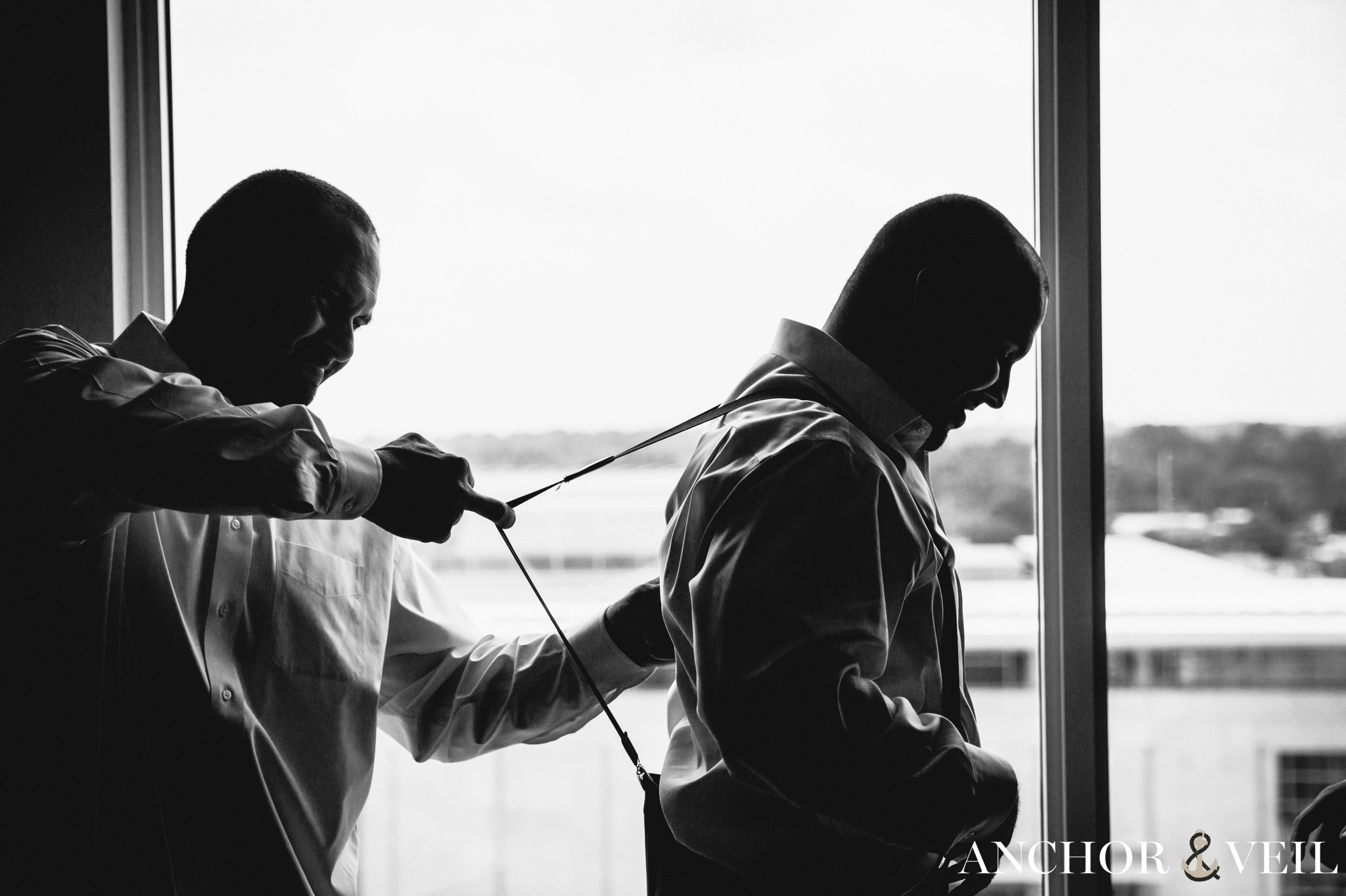groomsmen helping groom get ready