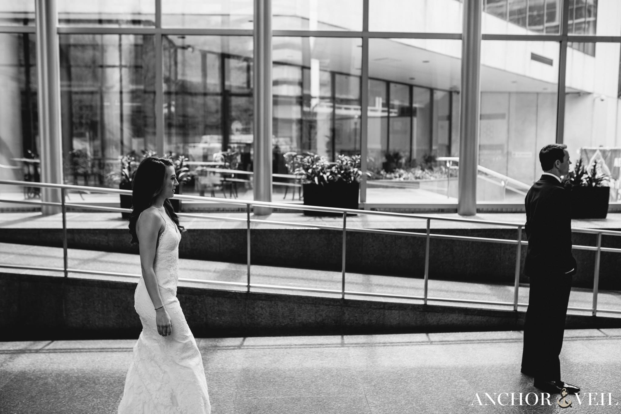 bride walking up behind groom during the first look at the omni hotel