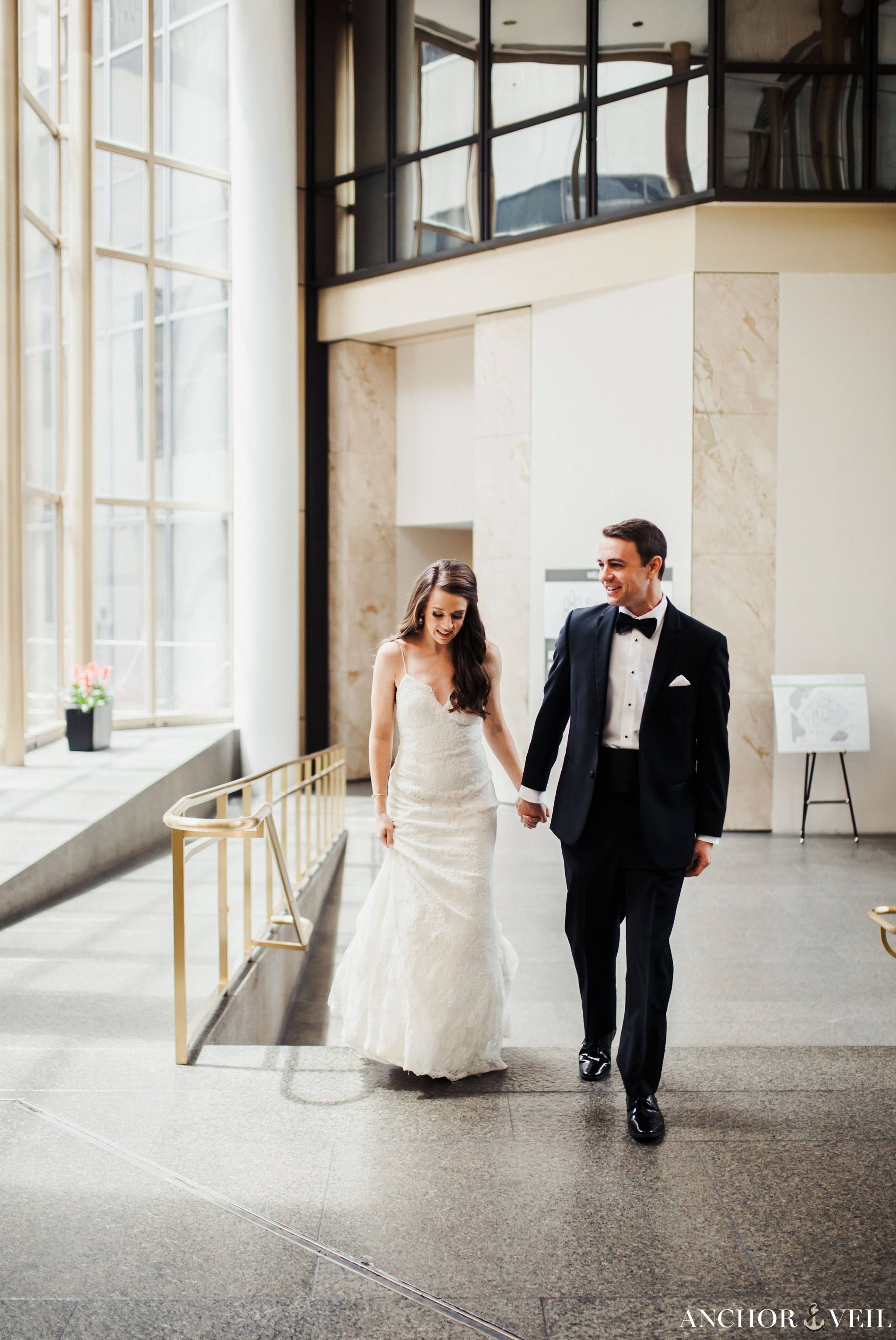 bride and groom hand in hand at the omni hotel