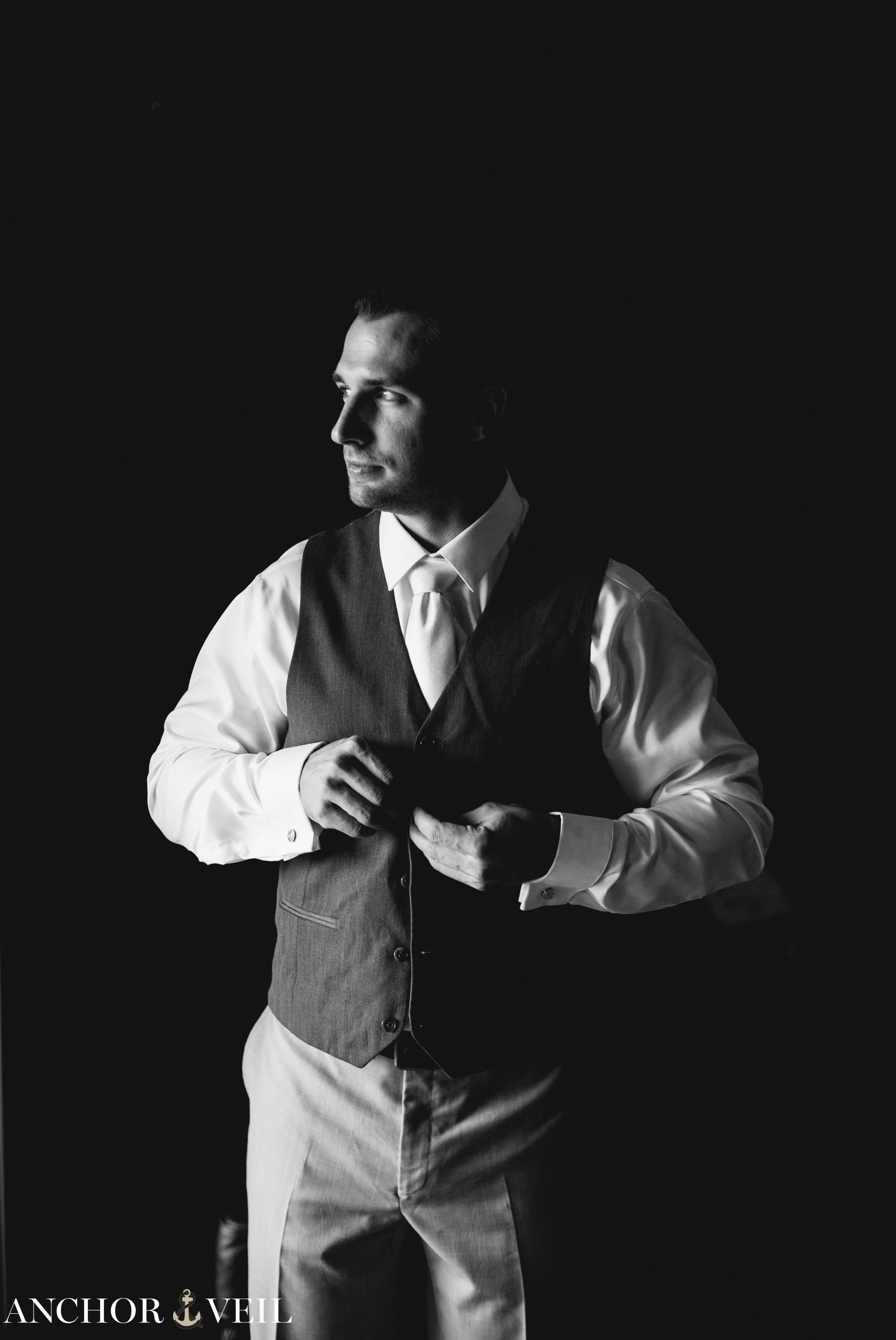 groom buttoning vest during the asheville mountains destination wedding