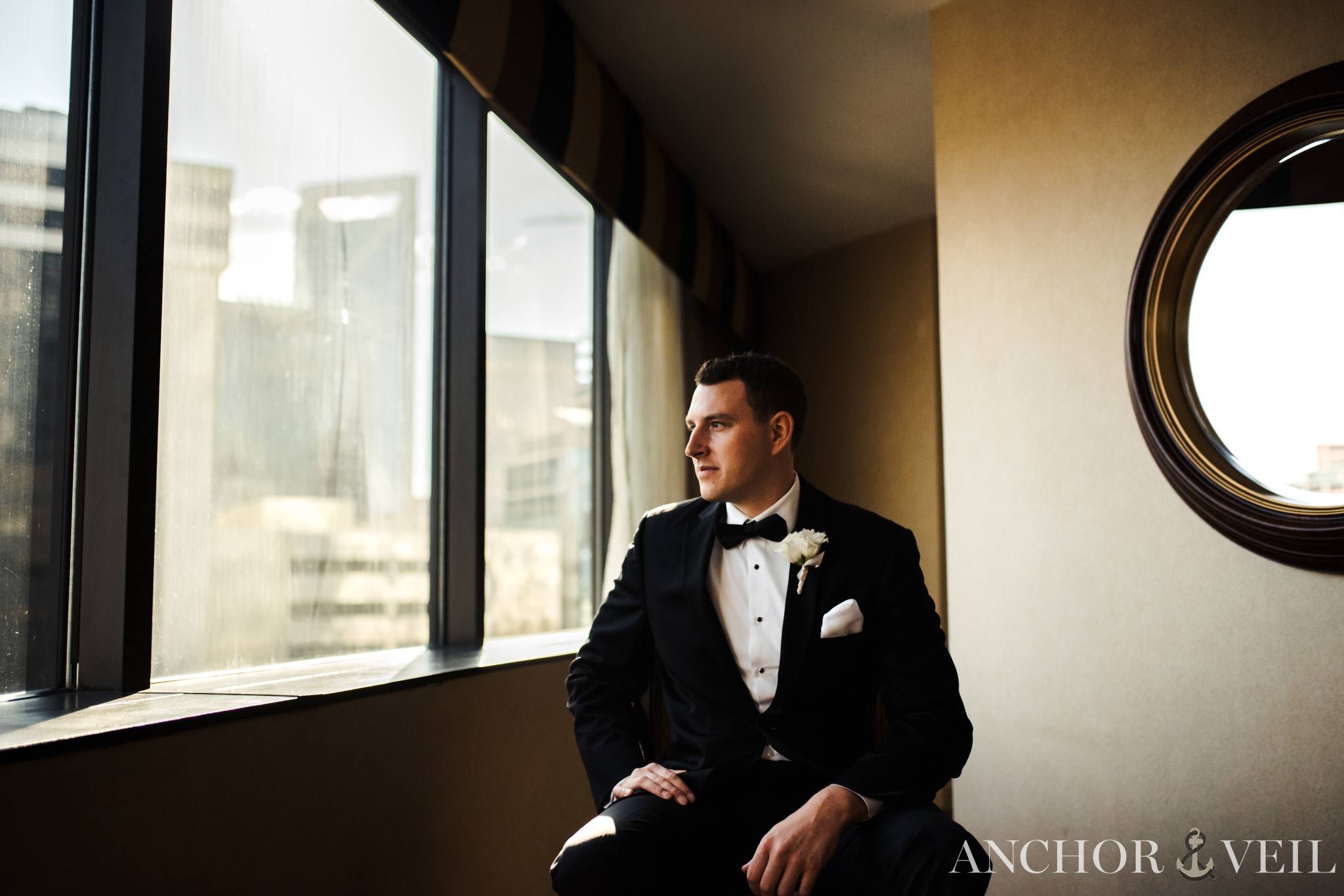 groom looking at the charlotte skyline while getting ready