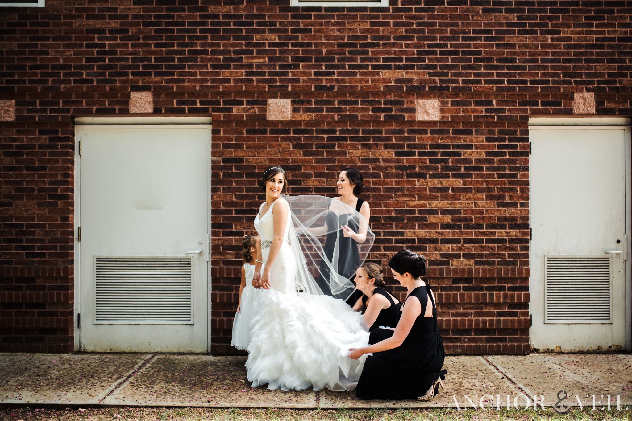 bride and her bridesmaids helping her to get ready