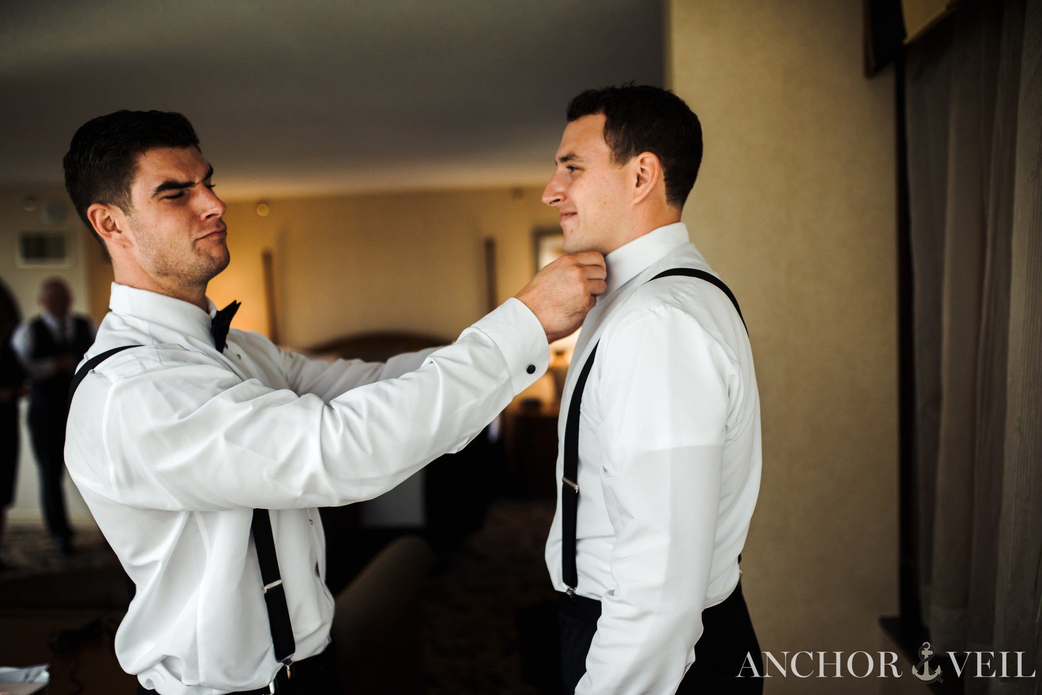 brother helping groom get ready at omni hotel