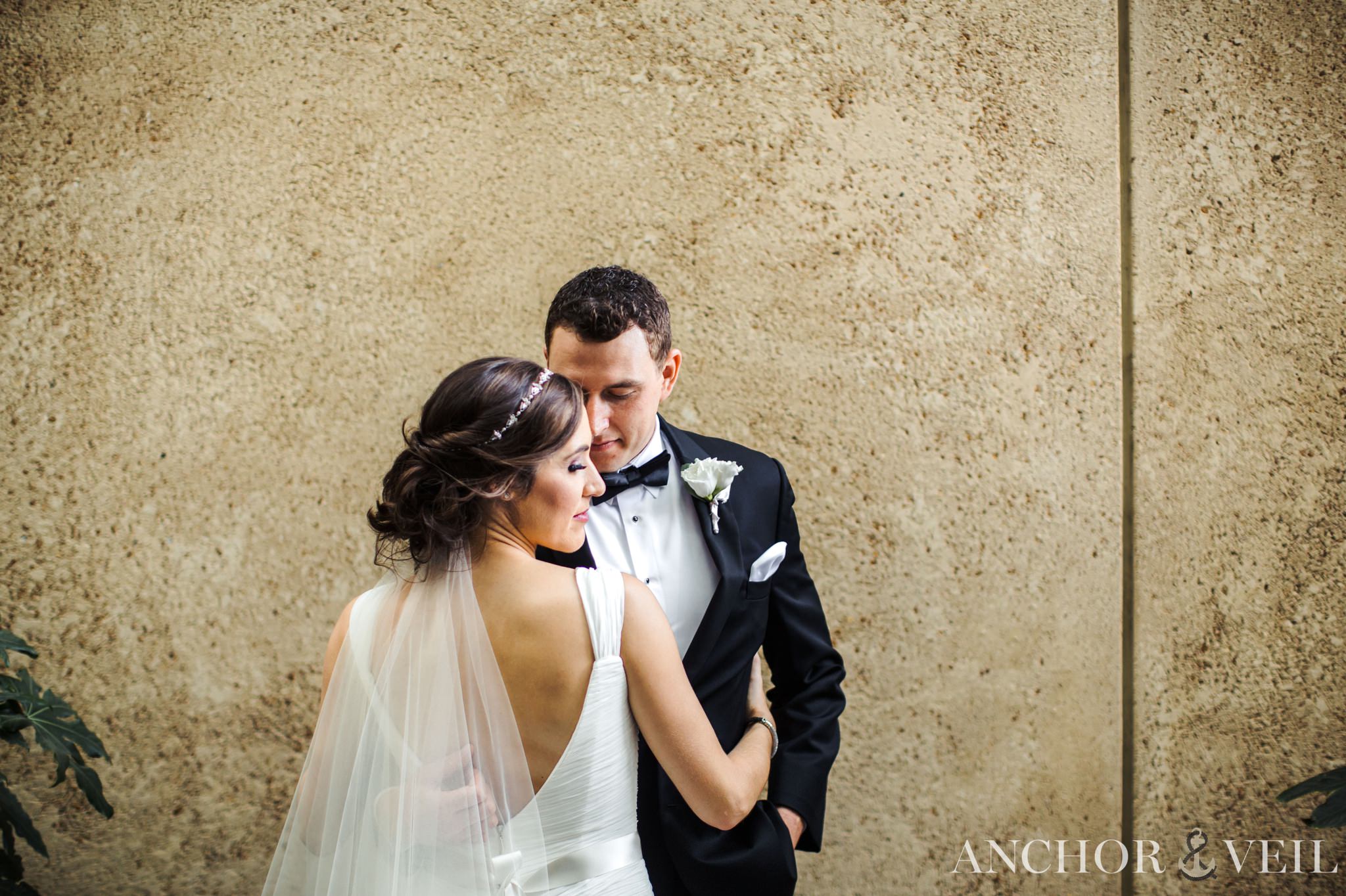 bride and groom together against the wall in uptown charlotte wedding