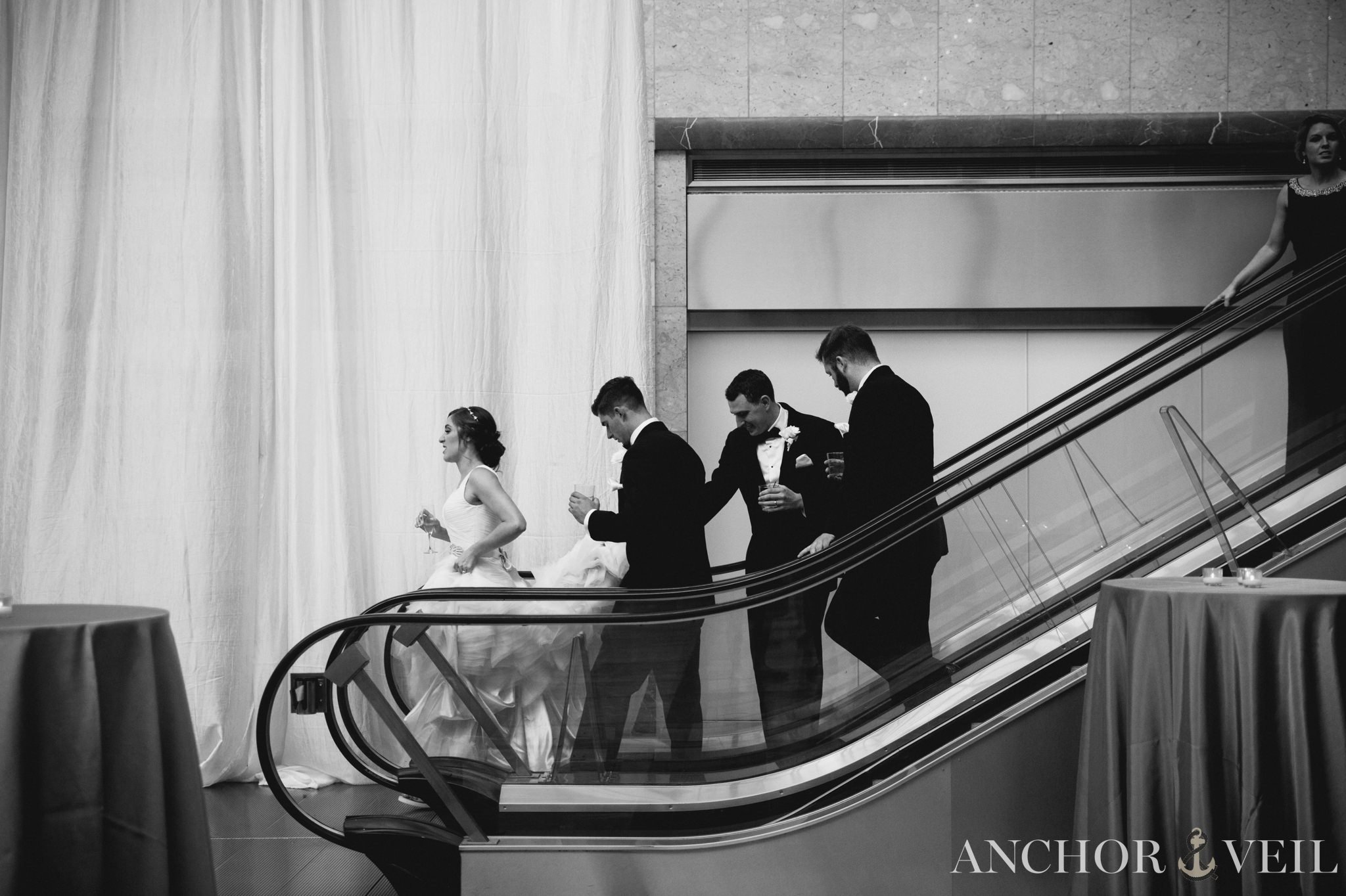 walking down the elevator during the reception founders Hall wedding in Charlotte Nc