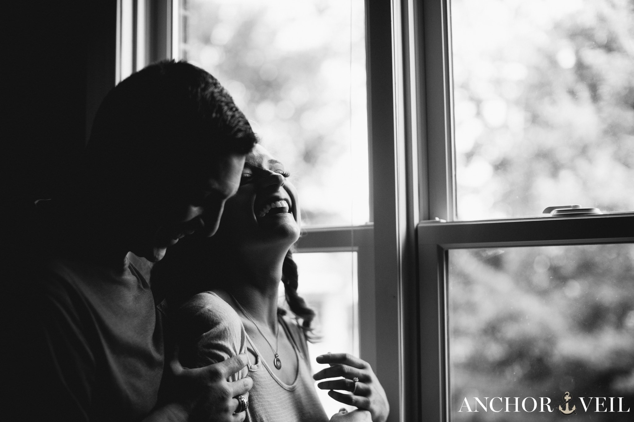 cuddled next to a window during the In Home Charlotte Engagement Session