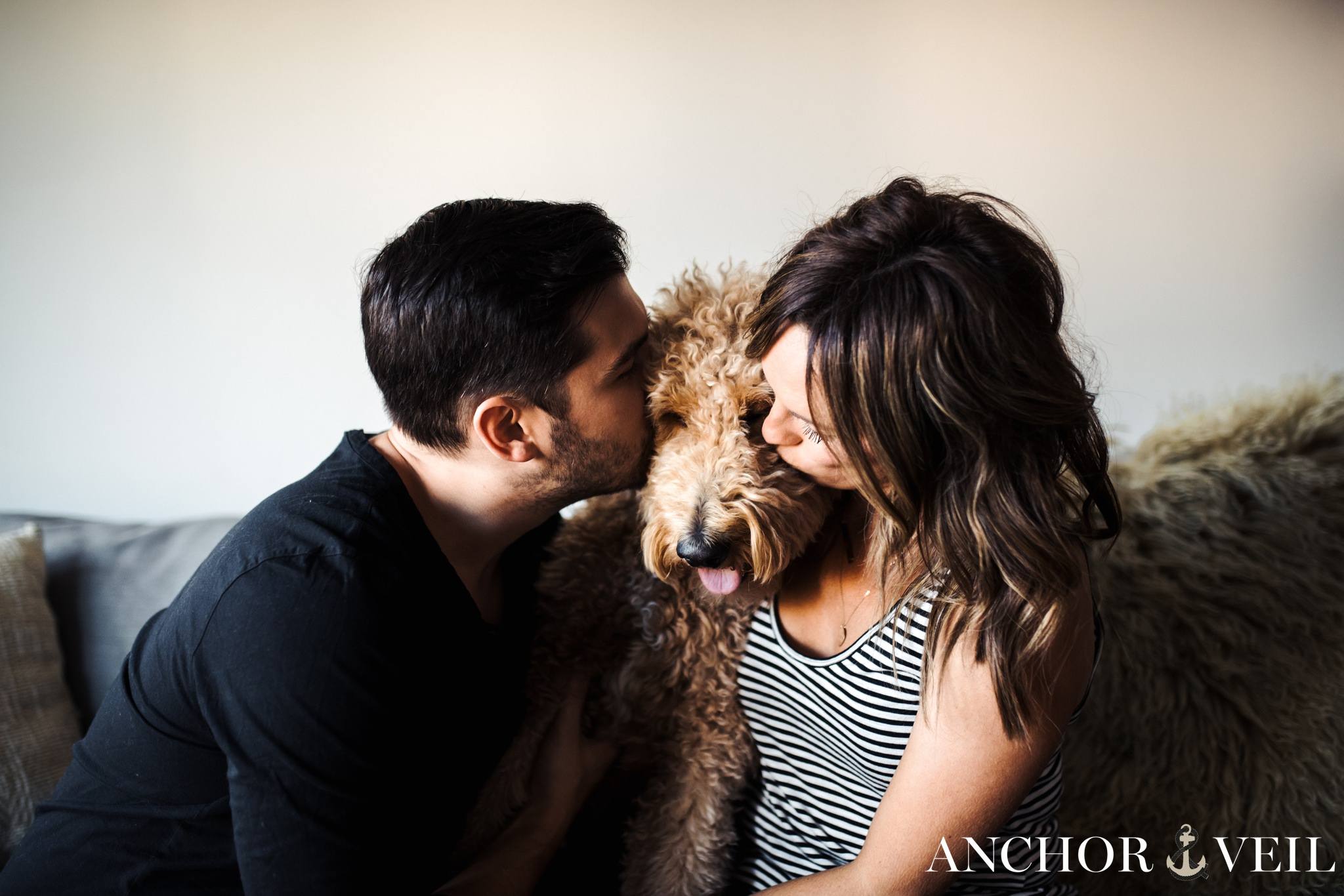 owner kisses sandwich with the golden doodle dog in the middle during the Charlotte in home session