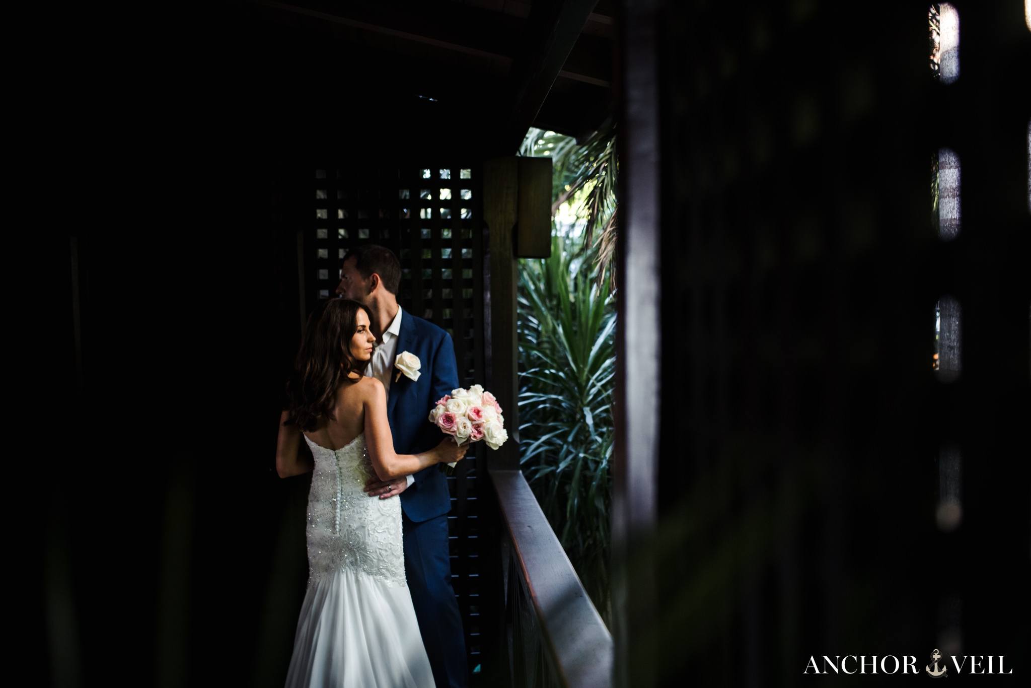 on the porch in the light holding each other at the Hermitage Bay Antigua Wedding