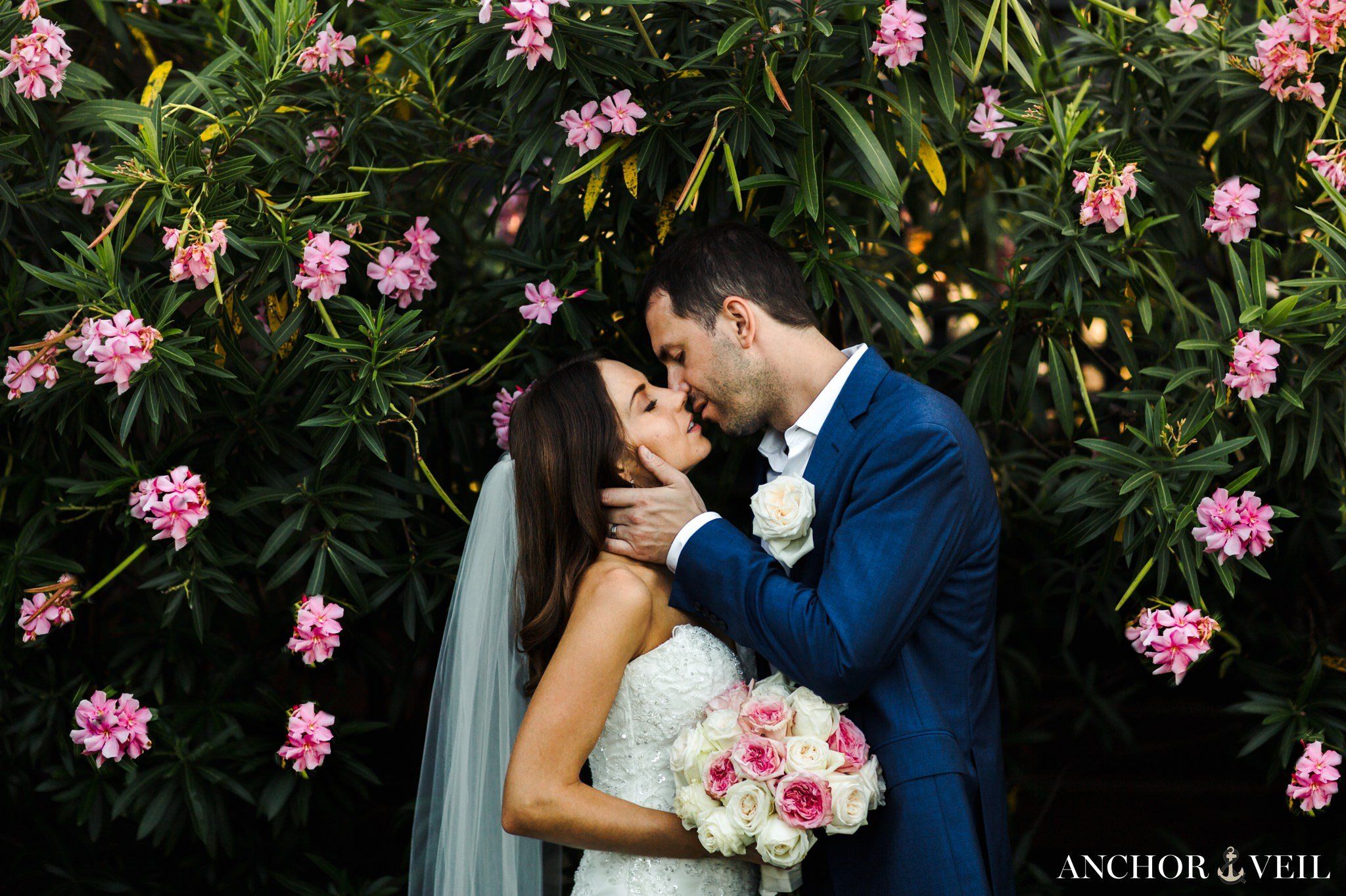 bride and groom kissing in the flowers