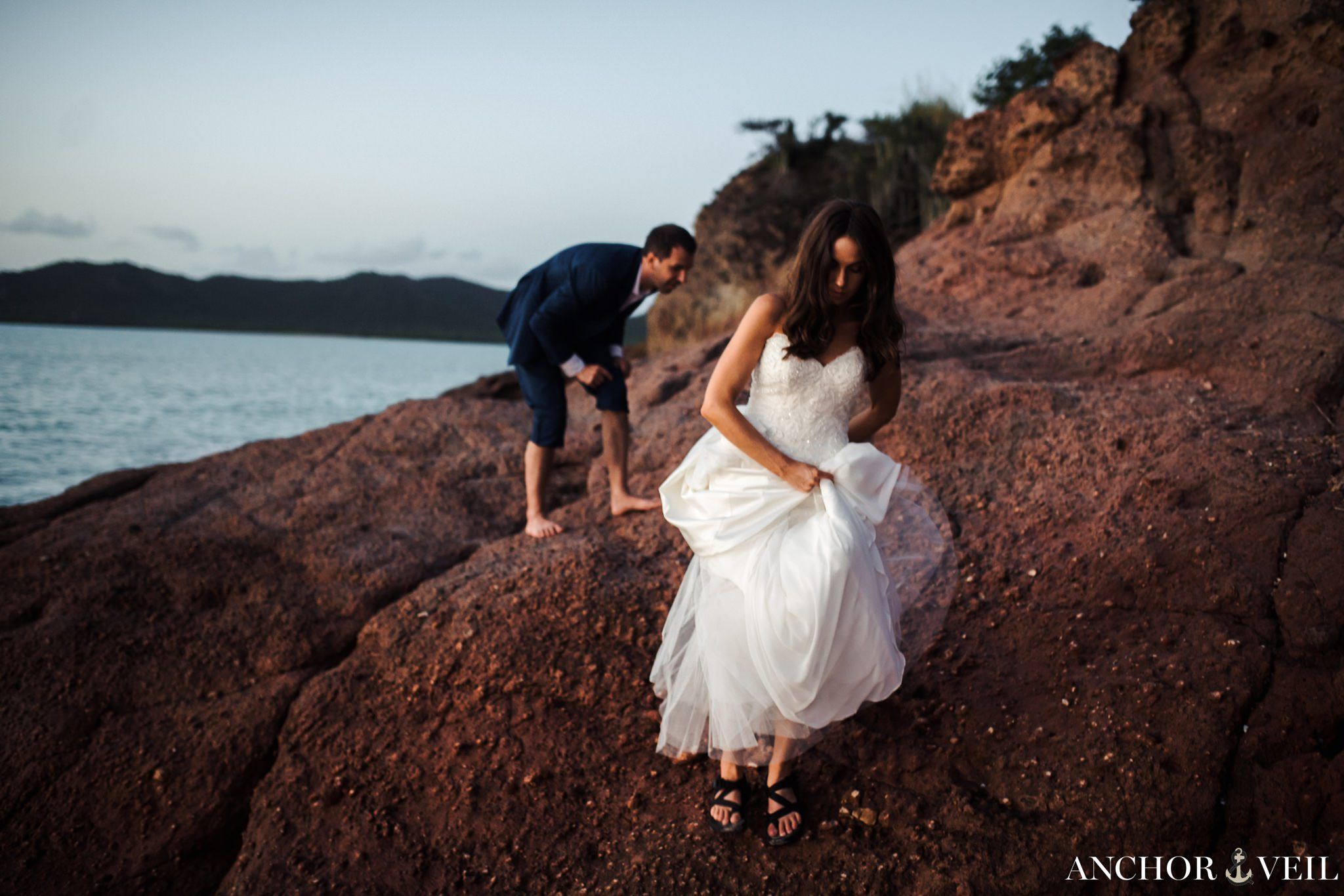 walking off of the rocks in chacos and bare feet during the Hermitage Bay Antigua Wedding