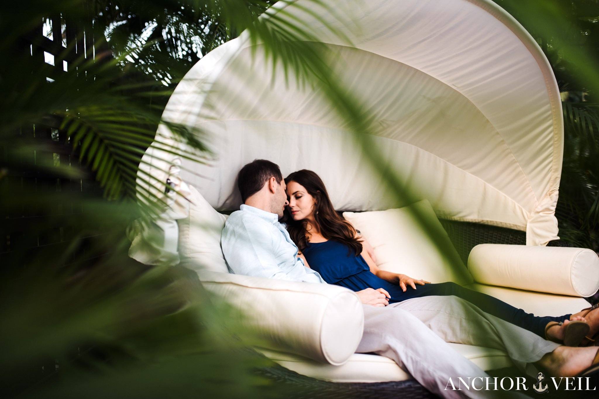 sitting in the large canopy chair by the p[ool at Hermitage Bay wedding Shoot