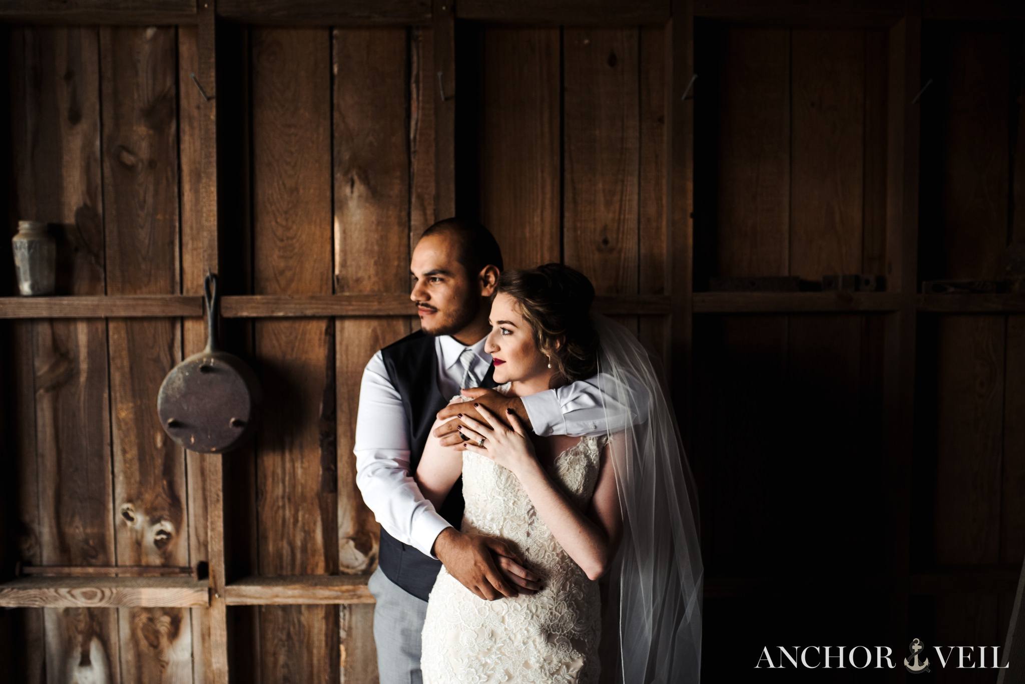 the side light as he holds her tight in the barn at the Hunting Creek Farms Wedding