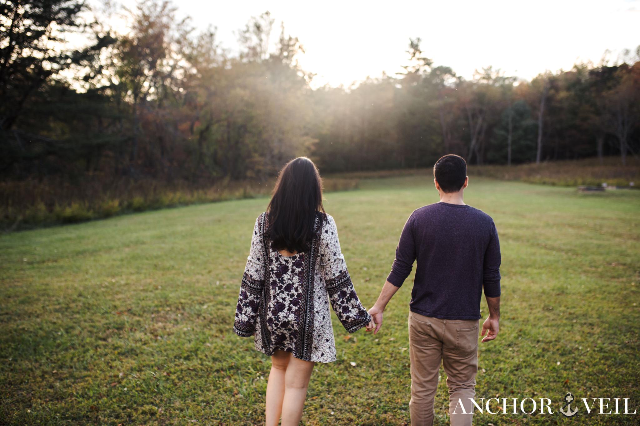 walking through the filed together during the Stone Mountain Engagement Session