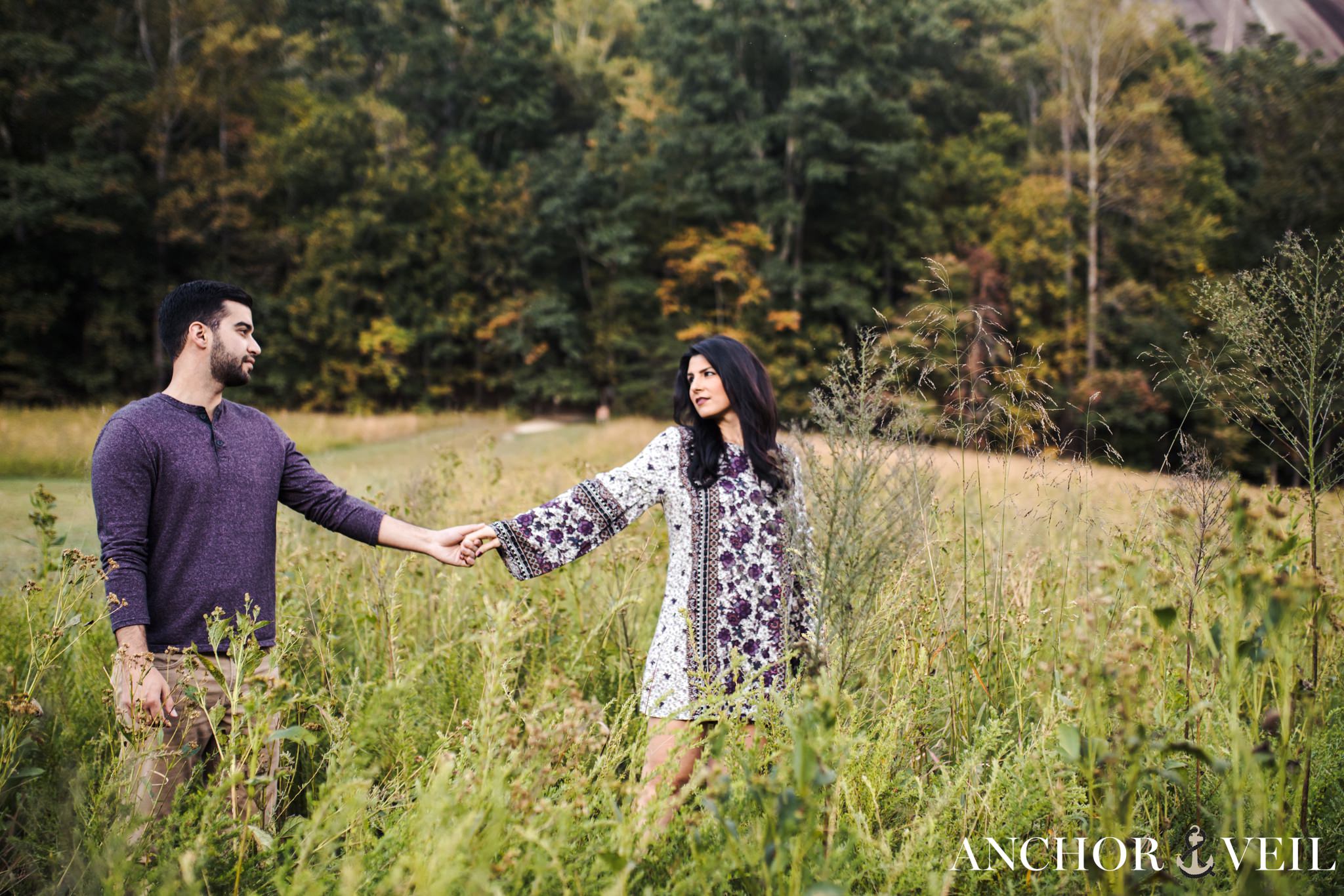 walking through the bushes hand in hand during the Stone Mountain Engagement Session