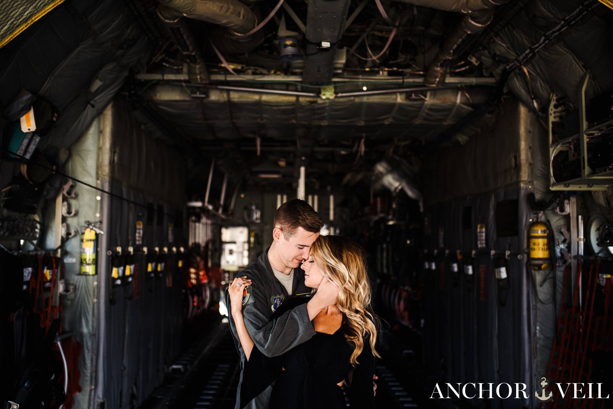 grabbing her face to kiss her in the plane during the aviation themed engagement session in Charlotte NC