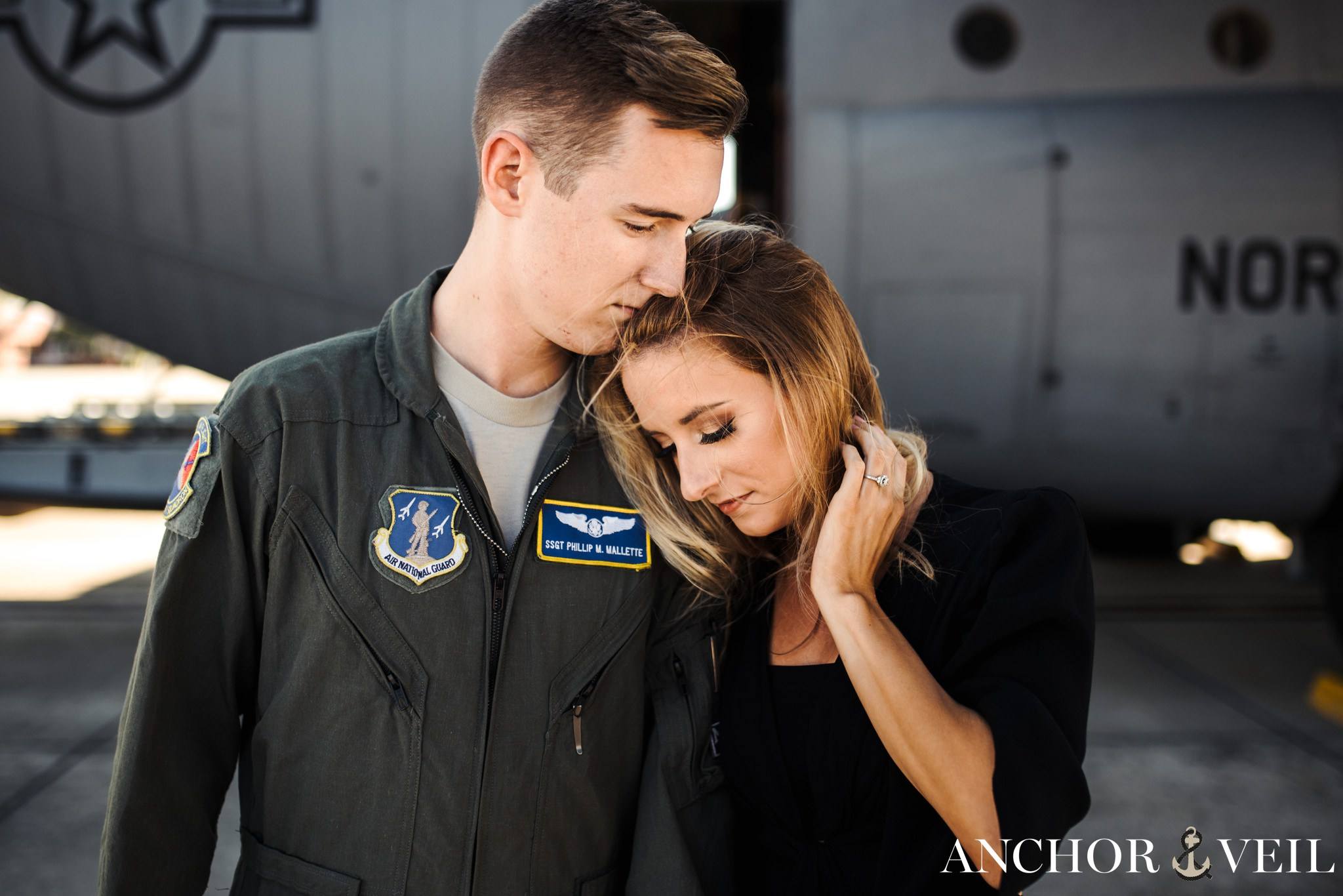 Leaning on his shoulder during the aviation themed engagement session in Charlotte NC