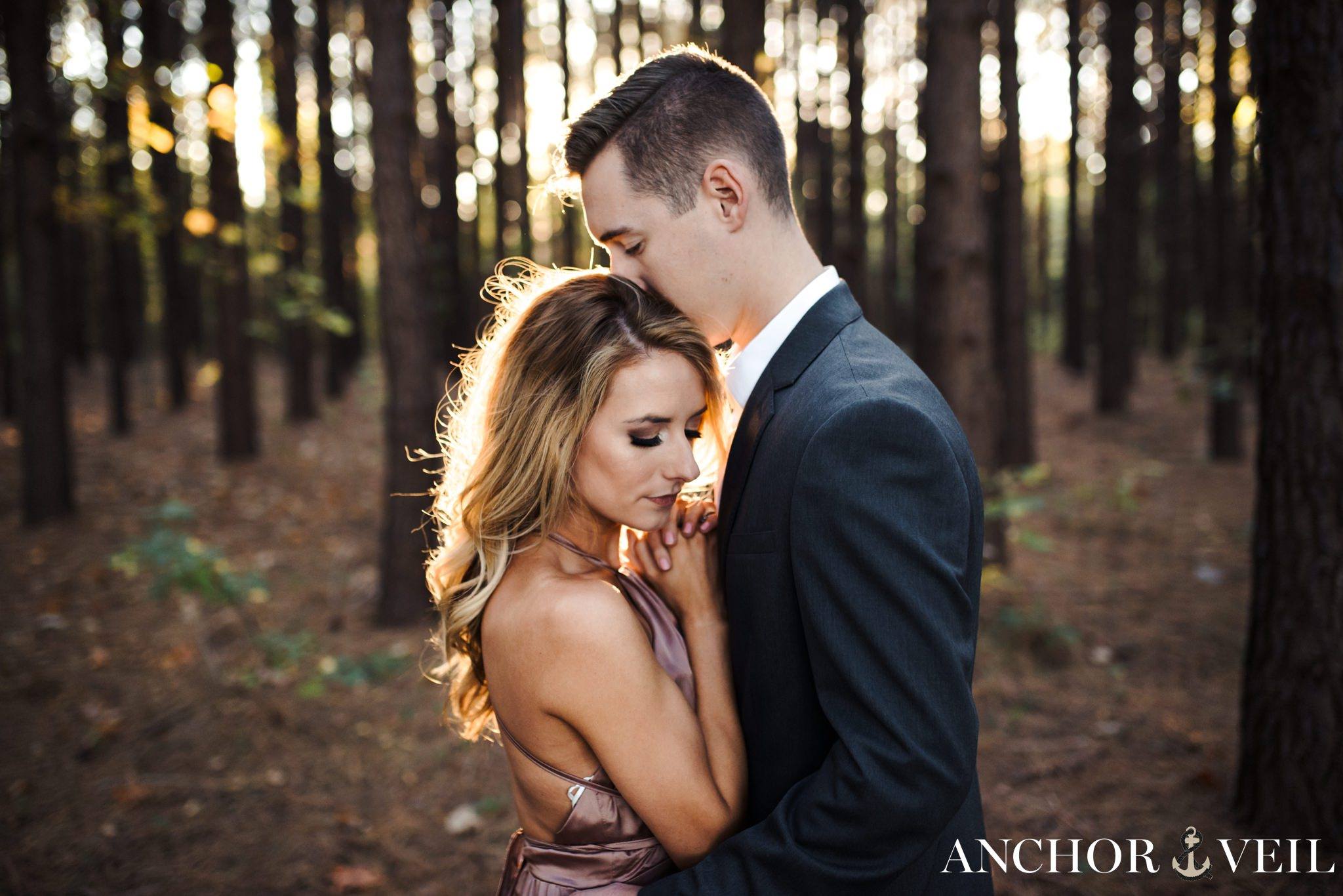 kissing her in the tree forest during their charlotte engagement session